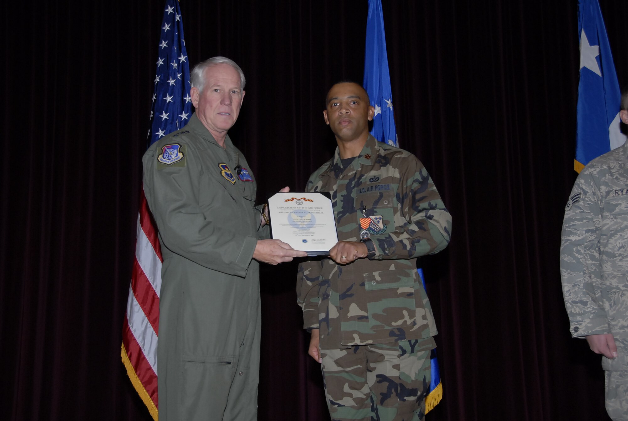 Gen. William R. Looney III, Air Education and Training Commander, presents the Combat Action Medal to Maj. Larry Harris, 82nd Civil Engineer Squadron operations flight chief, at the base theater Nov. 29. (U.S. Air Force photo/Mike Litteken)