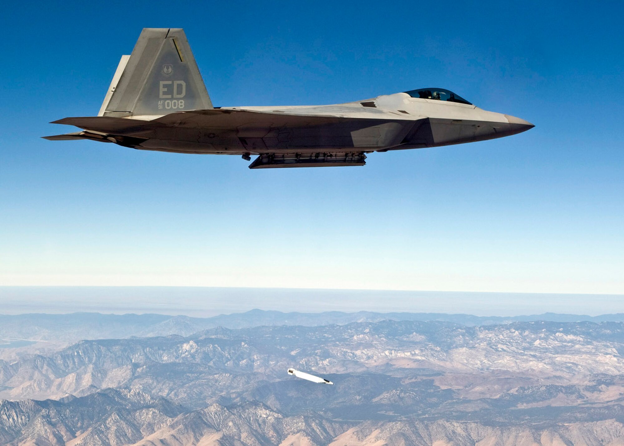 An F-22 Raptor drops a small diameter bomb from its weapons bay during a test mission Sept. 5 over Edwards AFB. Calif. The drop was made to ensure the small diameter bomb would have a safe, clean separation when released from the F-22. (photo by Darin Russell)
