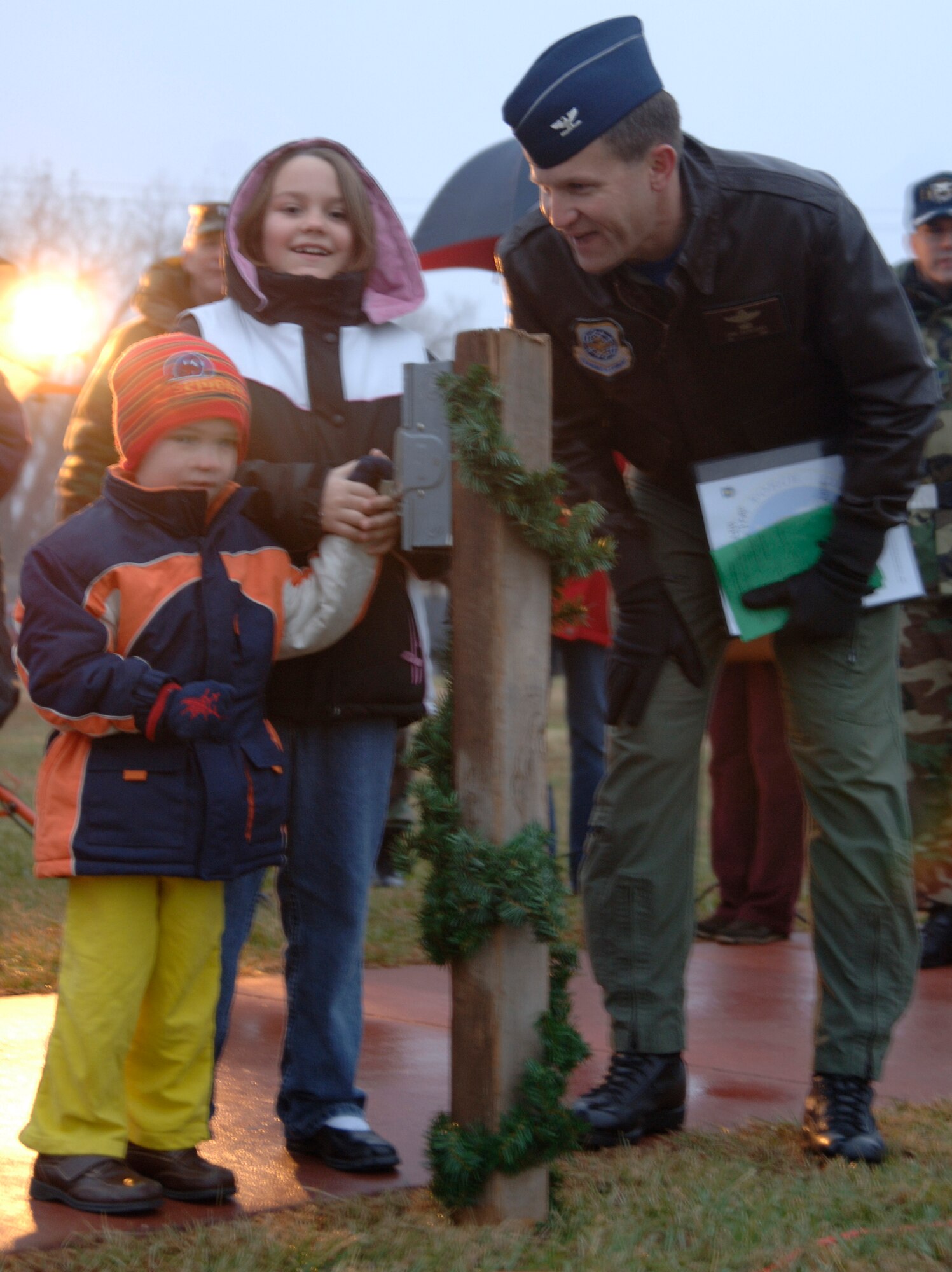 MCCONNELL AIR FORCE BASE, Kan. -- Trenton and Allyson McDonald help Col. John Zazworsky, 22nd Air Refueling Wing acting commander, light the holiday tree at the front gate on Dec. 7. Trenton and Allyson were invited to light the tree during the holiday rree lighting ceremony while their father Staff Sgt. Terry McDonald, 22nd Operations Group, is deployed.  (Photo by Airman 1st Class Maria Ruiz)