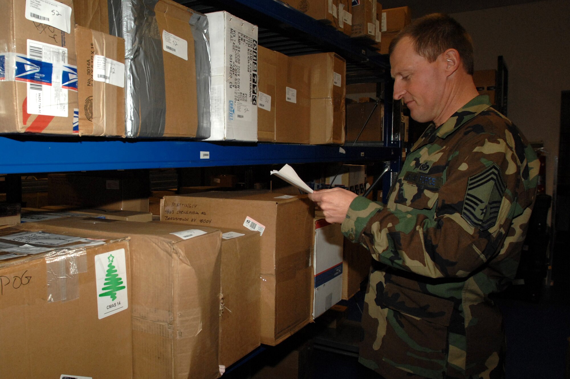 Chief Master Sgt. Dirk McDowell, chief enlisted manager of U.S. Air Forces in Europe logistics and installations missions support, looks for a package Dec. 11 at a post office at Ramstein Air Base, Germany.  Many people volunteer to help the post office staff with the overflow of packages during the holiday season. (U.S. Air Force photo/Airman 1st Class Amber Bressler)