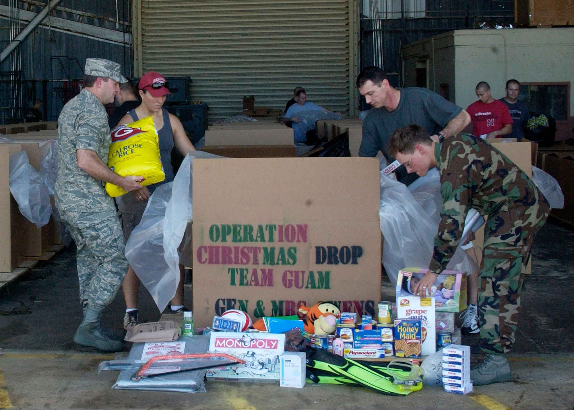 Brig. Gen. Douglas H. Owens (left) and members of Andersen Air Force Base, Guam, pack boxes for Operation Christmas Drop 2007 Dec. 8. This will be the 55th year of Operation Christmas Drop. Andersen AFB members are scheduled to make 74 drops over 71 islands, culminating in the largest Operation Christmas Drop in the history of the base's effort to spread holiday cheer to people living in islands close to Guam. General Owens is the 36th Wing commander. (U.S. Air Force photo/Airman 1st Class Zachary Hunter)
