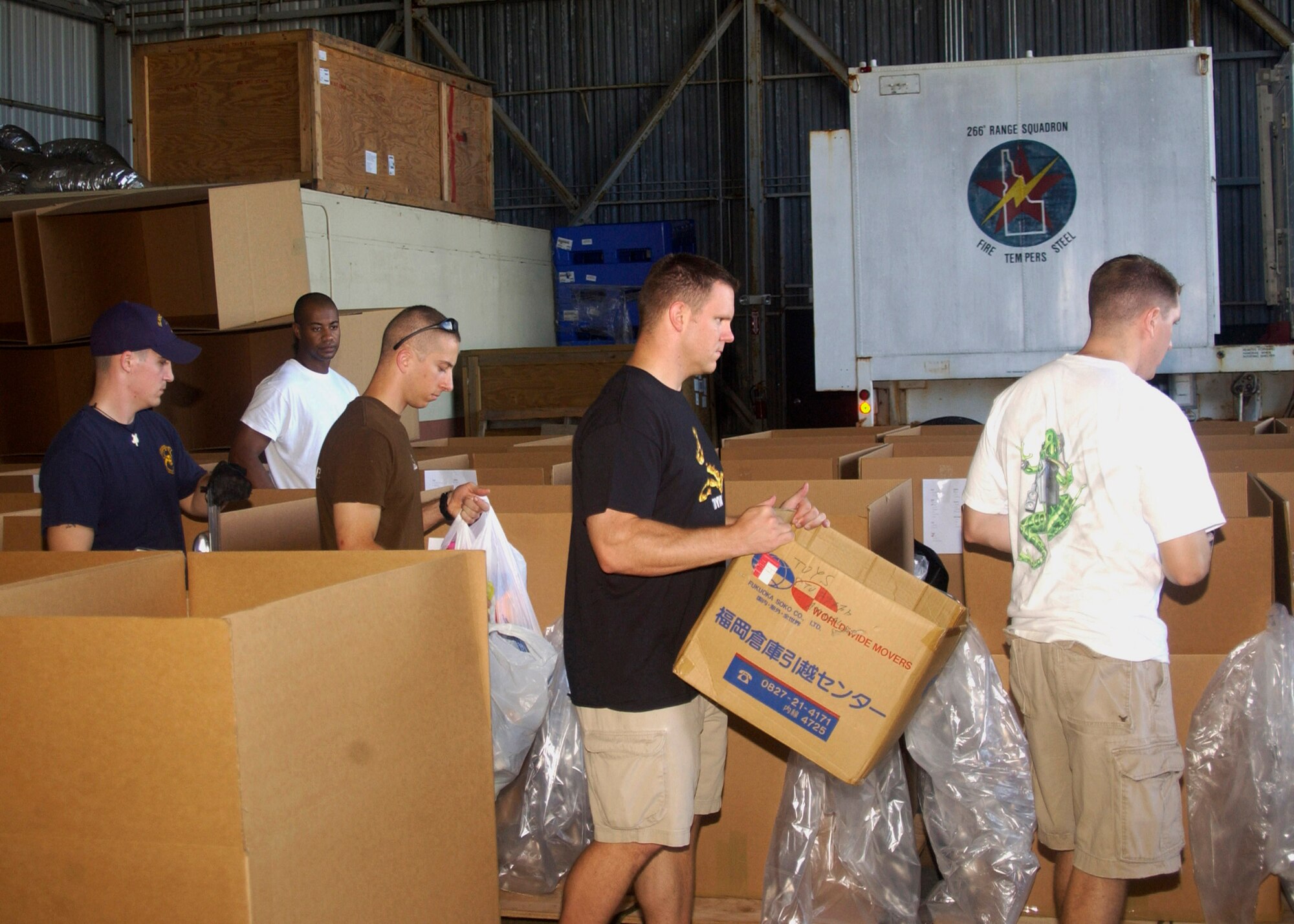 Volunteers pack boxes for the 2007 Operation Christmas Drop Dec. 8 at Andersen Air Force Base, Guam. This will be the 55th year of Operation Christmas Drop. Andersen AFB members are scheduled to make 74 drops over 71 islands, culminating in the largest Operation Christmas Drop in the history of the base's effort to spread holiday cheer to people living in islands close to Guam. (U.S. Air Force photo/Airman 1st Class Zachary Hunter) 
