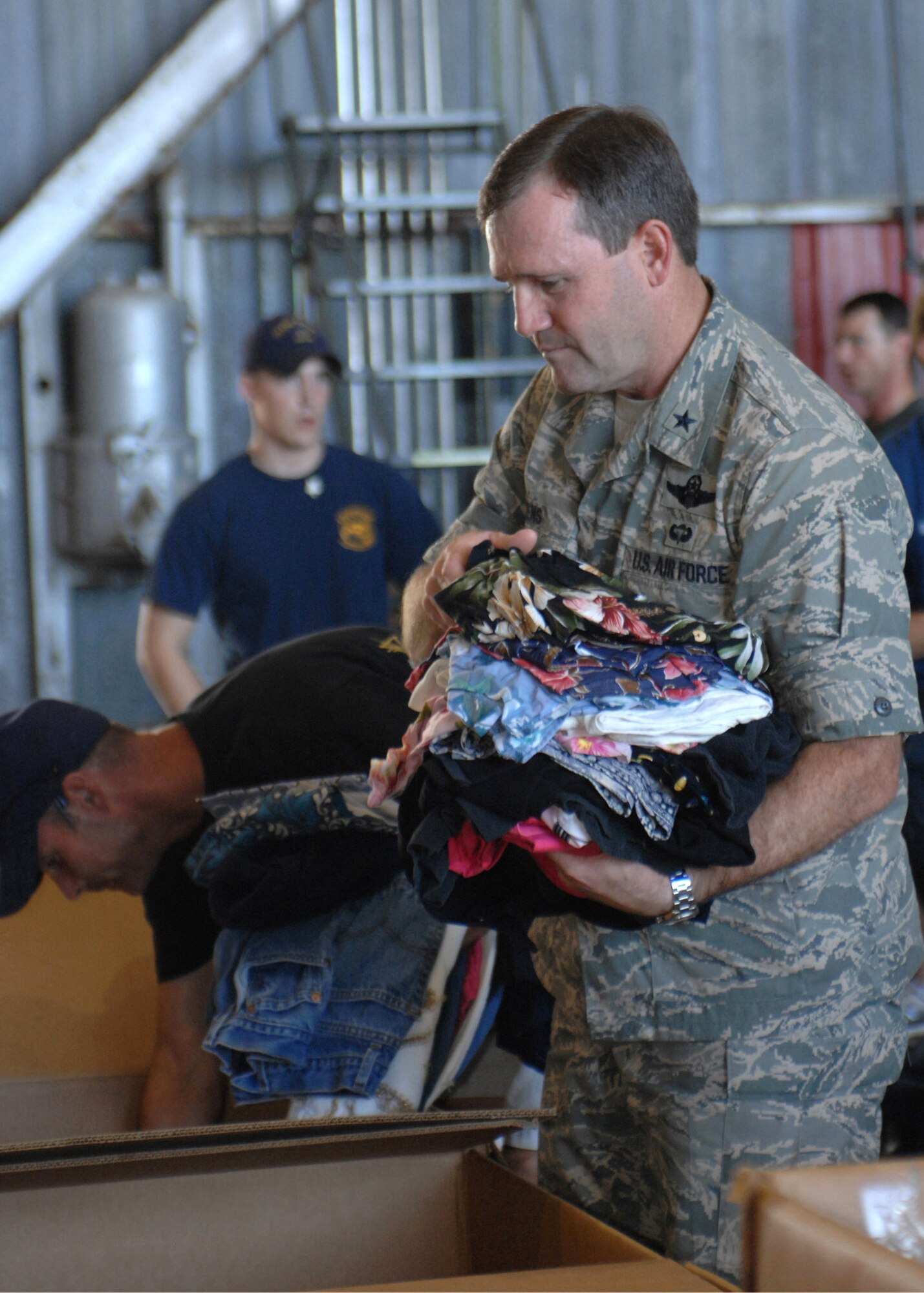 Brig. Gen. Douglas H. Owens and members of Andersen Air Force Base, Guam, pack boxes for Operation Christmas Drop 2007 Dec. 8. This will be the 55th year of Operation Christmas Drop. Andersen AFB members are scheduled to make 74 drops over 71 islands, culminating in the largest Operation Christmas Drop in the history of the base's effort to spread holiday cheer to people living in islands close to Guam. General Owens is the 36th Wing commander. (U.S. Air Force photo/Senior Airman Sonya Padilla) 
