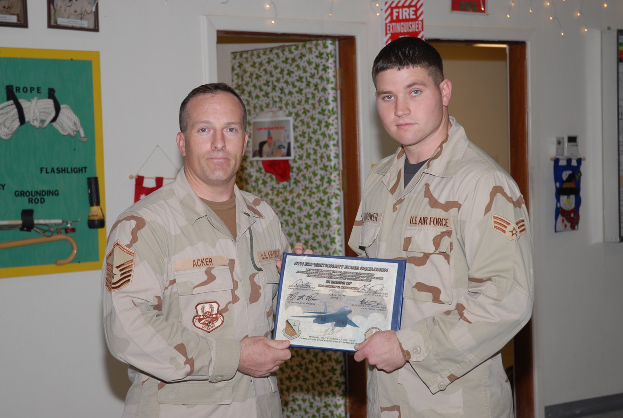 SOUTHWEST ASIA - Master Sgt Stephen Acker, Combined Air Operations Center,  congratulates Senior Airman Robert Harrower, 379th Expeditionary Maintenance Squadron, for being named a Hard Charger by his supervisors at a Southwest Asia air base Dec 10. The Hard Charger Award is presented to deserving airmen throughout the base on a monthly basis. (U. S. Air Force photo/Staff Sgt. Douglas Olsen)