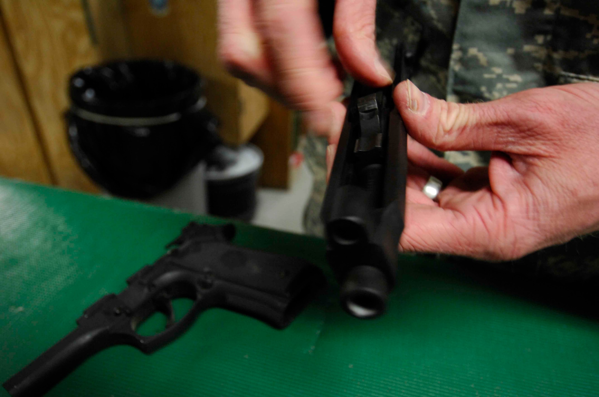 BAGRAM AIR BASE, Afghanistan - Aircrew life support technician Tech. Sgt. Ryan McMaster, 774th Expeditionary Airlift Squadron cleans an M-9 pistol before putting it back into a secure gun rack, Dec. 12, 2007.  (U.S. Air Force photo/Staff Sgt. Joshua T Jasper)  (Released)
