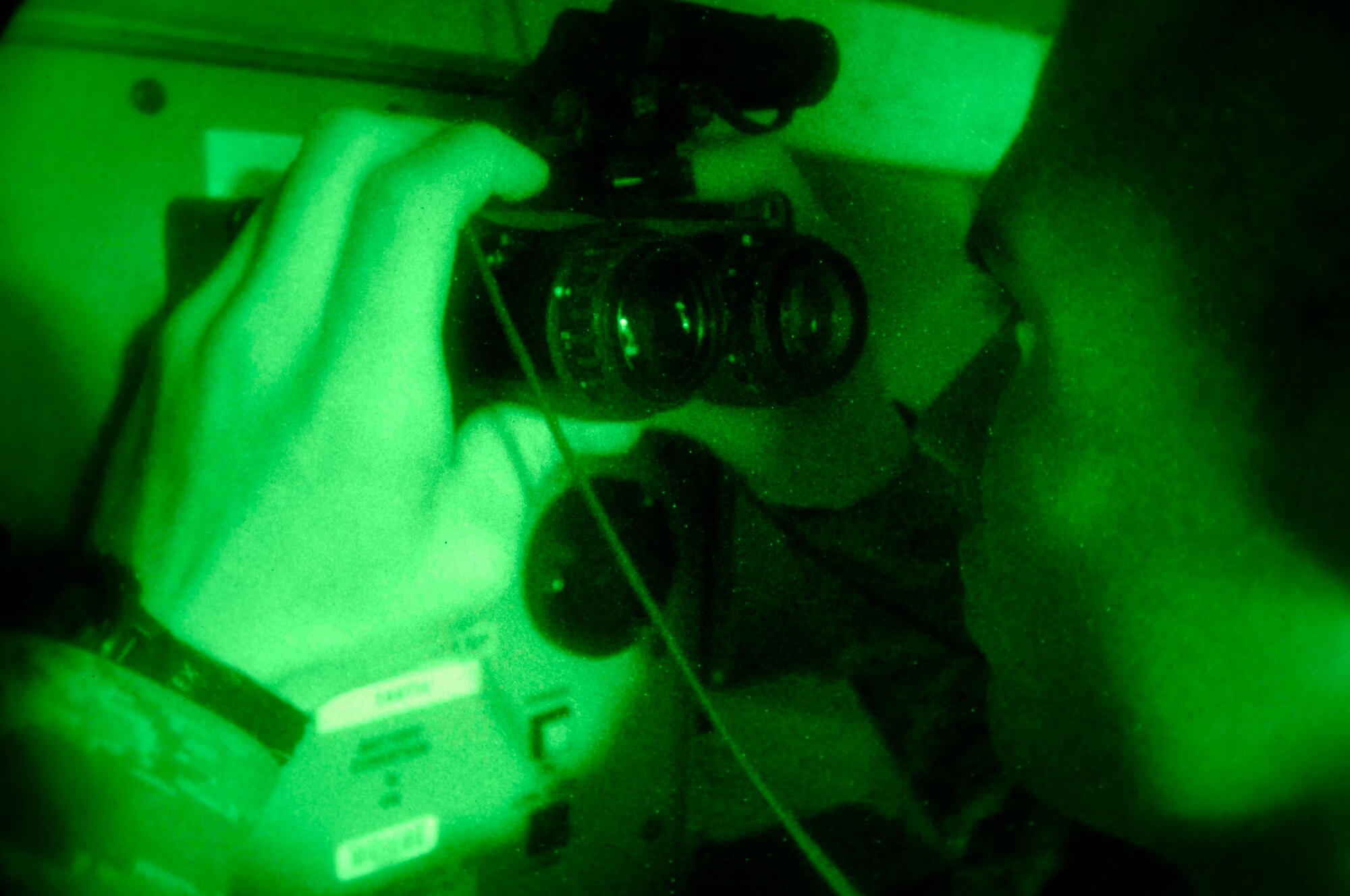 BAGRAM AIR BASE, Afghanistan - Senior Airman Jordan Cassity, an aircrew life support technician with the 774th Expeditionary Airlift Squadron here, checks a pair of night vision goggles in a dark room, Dec. 12, 2007.  (U.S. Air Force photo/Staff Sgt. Joshua T Jasper)  (Released)
