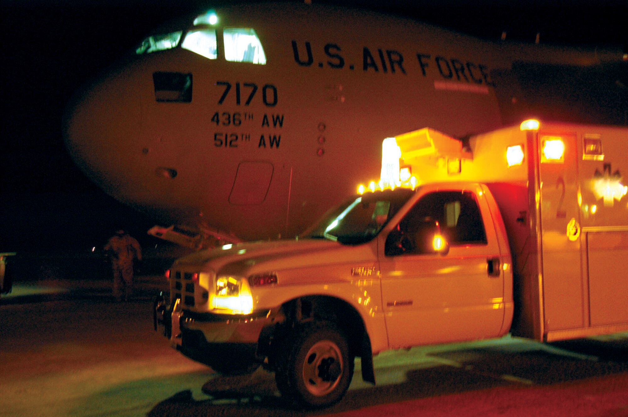 A base ambulance parks next to a C-17 Globemaster III from Dover Air Force Base, Del., Dec. 7 on the flightline at Thule Air Base, Greenland. With temperatures well below zero, the patient is quickly transferred onto the C-17 which flew from Ramstein Air Base, Germany, to Thule AB to transport a Team Thule member to a stateside medical treatment facility for emergency care. (U.S. Air Force photo/1st Lt. Nicole Langley)