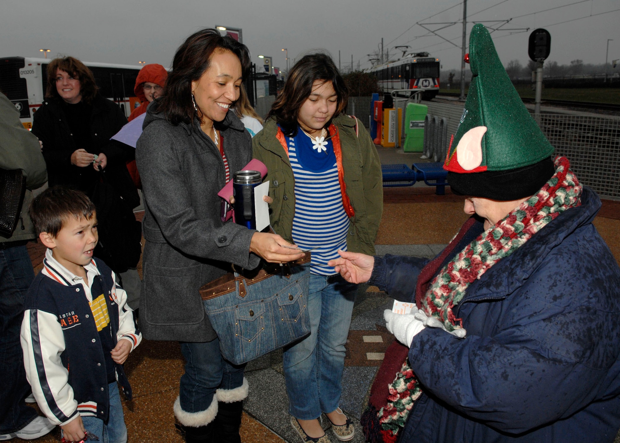 Margaret Mark, USO volunteer, gives away free MetroLink tickets to Joint Total Force Scott families during the USO’s Santa Express Dec. 8 at Union Station. (U.S. Air Force photo by Airman 1st Class Megan Gilliand)