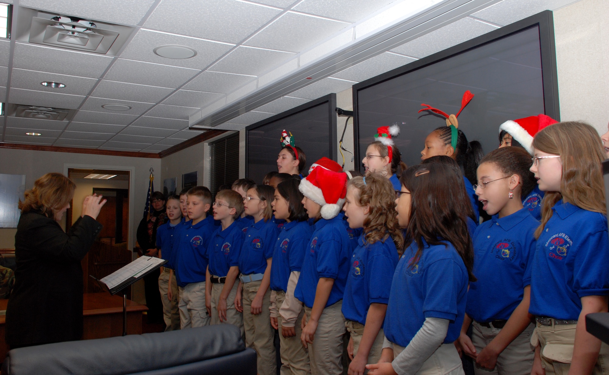 Judy Aldaco, Sheppard Elementary School choir director, leads members of the Sheppard Elementary choir Dec. 14 in the wing conference room. The choir started out by signing for 82nd Training Wing Commander Brig. Gen. Richard Devereaux, and then sang at the Sheppard clinic, the base exchange and at a school luncheon held for volunteers. (U.S. Air Force photo/Airman 1st Class Jacob Corbin)