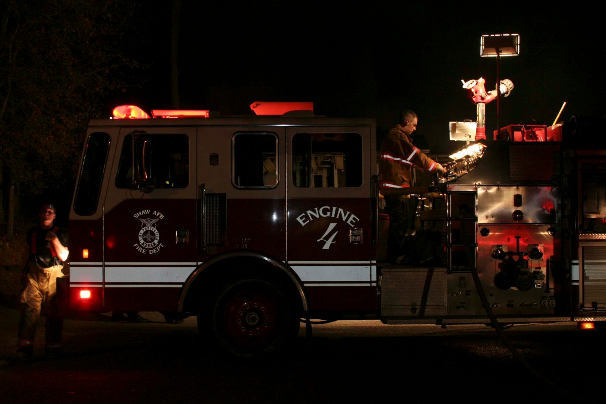 Sumter, S.C.-- Ariman 1st Class Adam Stephen, 20th Civil Engineer Squadron  firefighter, operates a pump panel while Airman Michael
Waffle, 20th CES firefighter, takes a breather at an off-base house-fire Dec. 11. Shaw operates in the local community under a memorandum of understanding
with Sumter County Fire Department.  If Sumter units are otherwise occupied
or unavailable, they contact the Shaw Fire Department to respond to the
incident. (U.S. Air Force photo/Airman 1st Class Michael Cowley)

