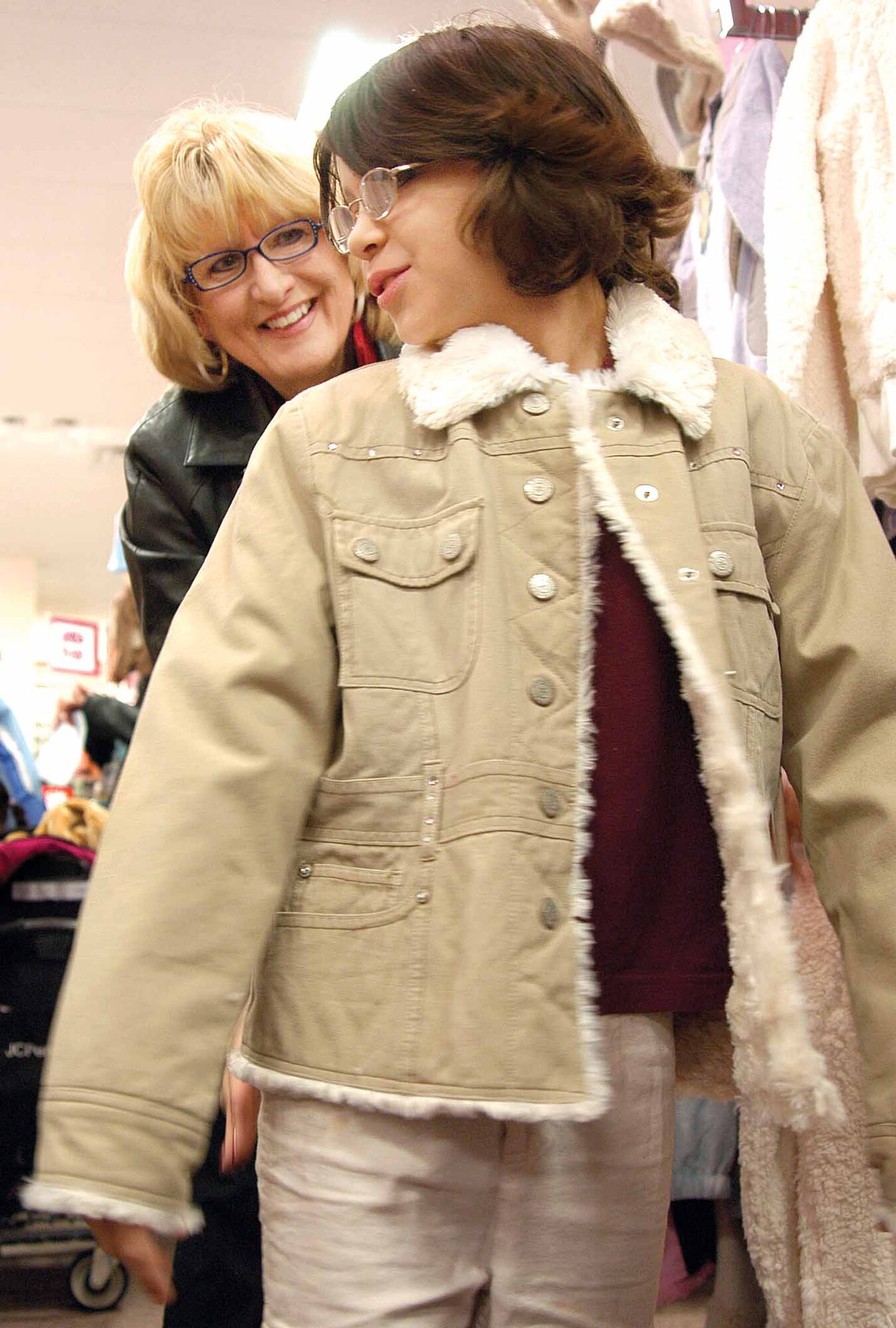 Retha Lucas, B-52 Program Office, enjoys watching 10-year-old Cassie Winckleblack admire a new coat in the mirror at JC Penney during the annual Christmas program that teams B-52 volunteers with area students to shop for clothes including shoes, a coat, pants and tops. Cassie said her mom “jumped up and down” when she learned her two daughters had been selected by the Mid-Del schools to benefit from the program. (Air Force photo by Margo Wright)
