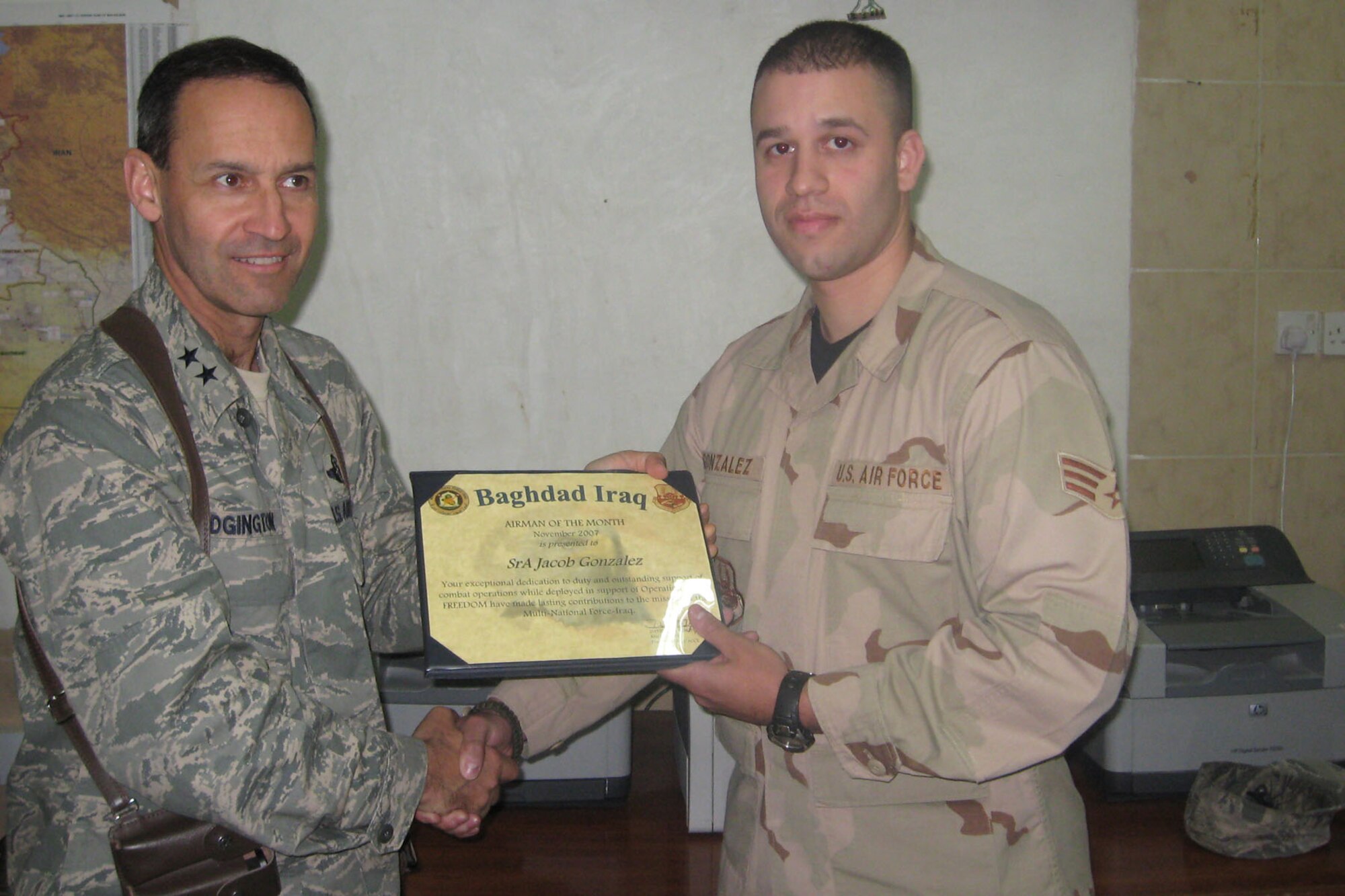 Maj. Gen. David Edgington presents the Baghdad Airman of
the Month award to Senior Airman Jacob Gonzales from the 96th Communications Squadron.  The general is the Director of Air Component Coordination Element, Multi-National Force-Iraq, Baghdad, Iraq. He was the Vice Commander of the Air Armament Center from March 2004 until June 2005.