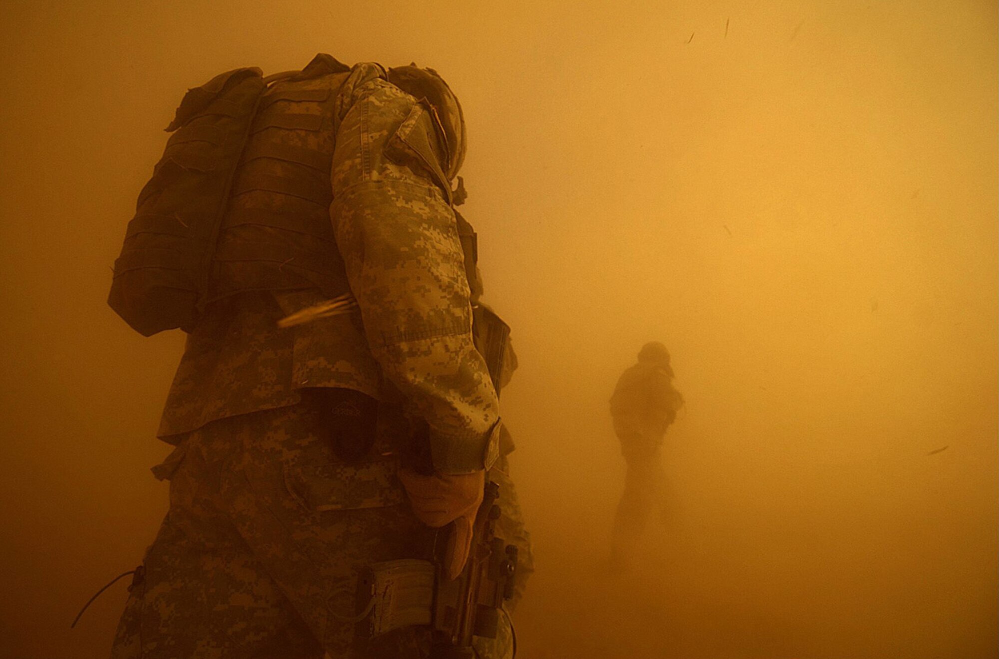 A dust cloud envelops members of B Company, 4-23 Infantry Regiment, 172nd Stryker Brigade Combat Team, during an air assault mission near Tall Afar, Iraq, on June 5, 2006. (Photo by Staff Sgt. Jacob Bailey)