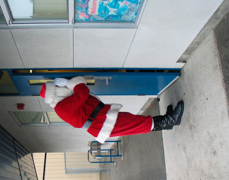 TRAVIS AIR FORCE BASE, Calif. -- Santa takes a peek into a classroom at Lincoln Elementary School, Vallejo, Calif., during this year's Operation Teddy Bear, 7 Dec.  OTB, sponsered by the 349th Wing Top Three Council, is an annual mission to bring a little joy to local area school children by providing each with a Teddy bear and a visit from Santa. Santa's stand-in was played (at all schools) by Staff Sgt. Bryan Nalette, a Loadmaster from the 312th Airlift Squadron. (U.S. Air Force courtesy photo)