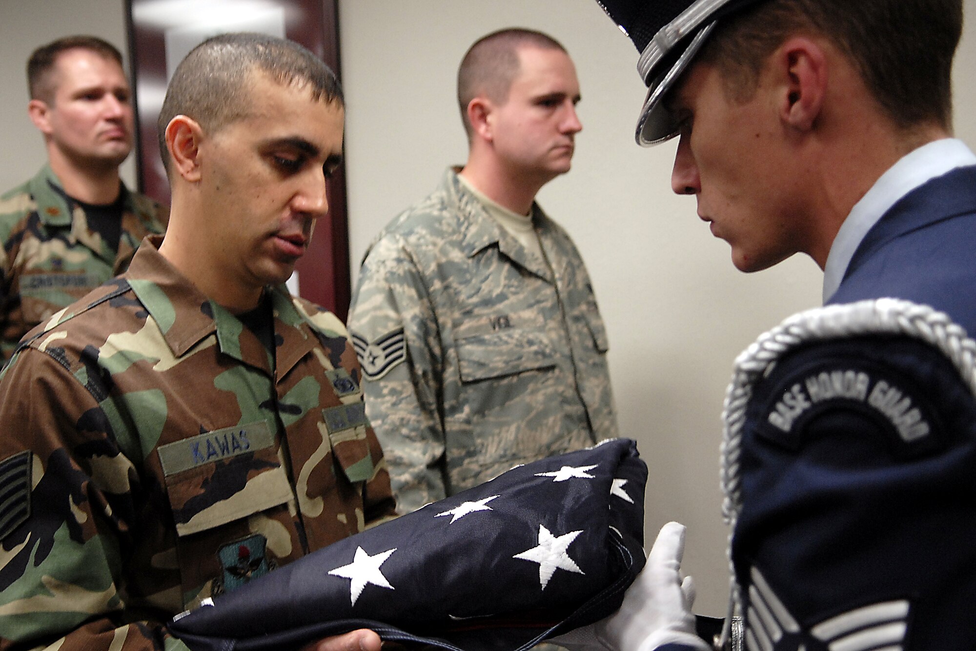 Accepting an American flag flown in honor of Military Working Dog Samson is Tech. Sgt. Rick Kawas, Samson’s military working dog handler with the 17th Security Forces Squadron. Military Working Dog Samson, who passed away earlier this month, was honored in a memorial ceremony Dec. 13 at the Goodfellow NCO Academy auditorium. (U.S. Air Force photo by Airman 1st Class Kamaile Chan)