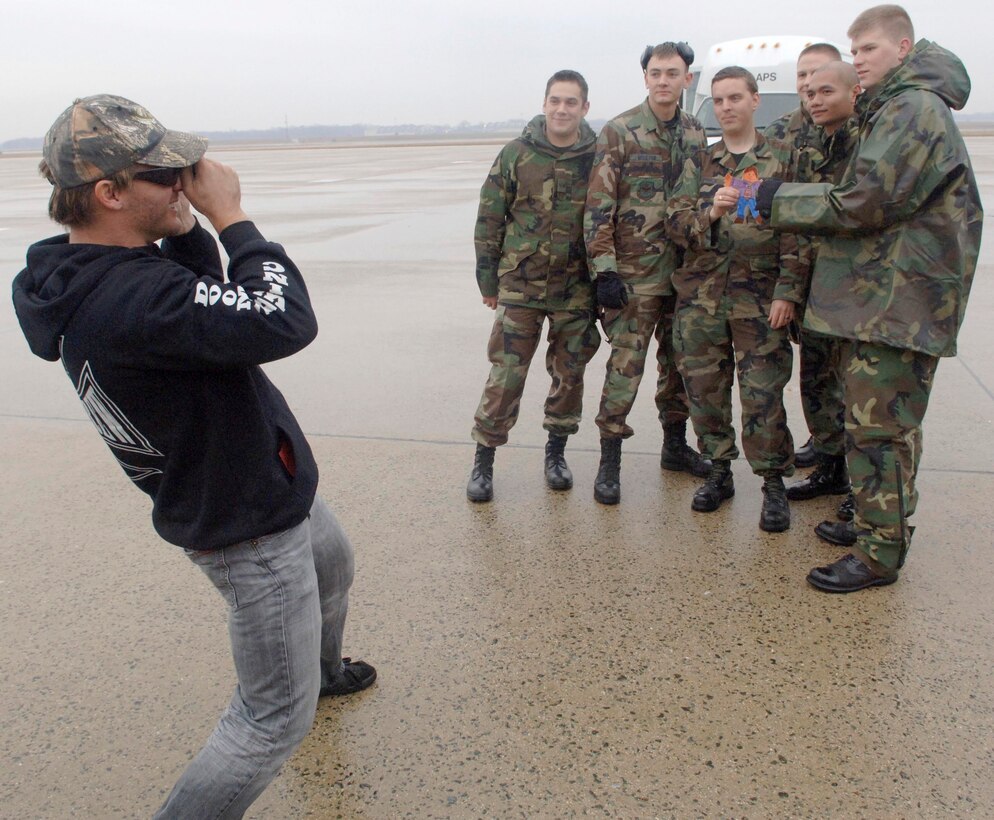 Professional Wrestler Christopher "Chris Jericho" Irvine, World Wrestling Entertainment superstar, becomes a phographer himself as he takes a picture of U.S. Air Force members on the flight line here on Dec. 8, upon his return home from a WWE USO tour. Jericho and other wrestlers from WWE returned home from a week long tour to perform for troops deployed to Iraq.