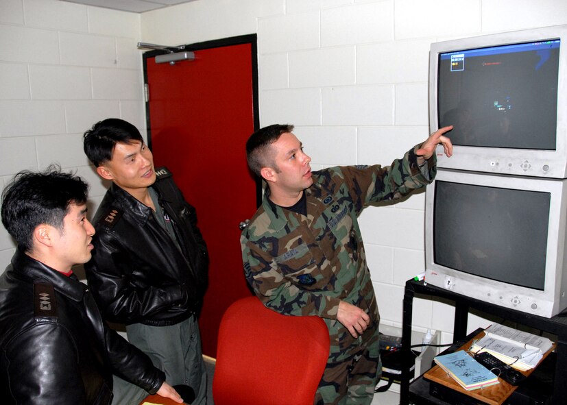 OSAN AIR BASE, Republic of Korea – Staff Sgt Charles Arata (right), a weapons director assigned to the 621st Air Control Squadron, debrief Captain Young-Kwon Ko (left) and Captain Jeong-Ho Cho, KF-16 Fighting Falcon pilots assigned to the 157th Tactical Fighter Squadron, Seosan Air Base, Republic of Korea Air Force after their Buddy Wing sortie with pilots from the 36th Fighter Squadron.  The purpose of the Buddy Wing program is to exchange ideas, introduce tactics and improve interoperability between the U.S. and Republic of Korea Air Forces.  (U. S. Air Force photo by Senior Master Sgt Marvin Krause)