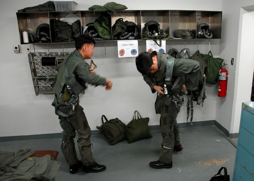 OSAN AIR BASE, Republic of Korea -- Captain Jeong-Ho Cho (left) and Captain Young-Kwon Ko (right) KF-16 Fighting Falcon pilots assigned to the 157th Tactical Fighter Squadron, Seosan Air Base, Republic of Korea Air Force, put on their life support equipment prior to a Buddy Wing sortie with pilots from the 36th Fighter Squadron during the Buddy Wing program 11 through 13 December.  The purpose of the Buddy Wing program is to exchange ideas, introduce tactics and improve interoperability between the U.S. and Republic of Korea Air Forces.  (U. S. Air Force photo by Senior Master Sgt Marvin Krause)