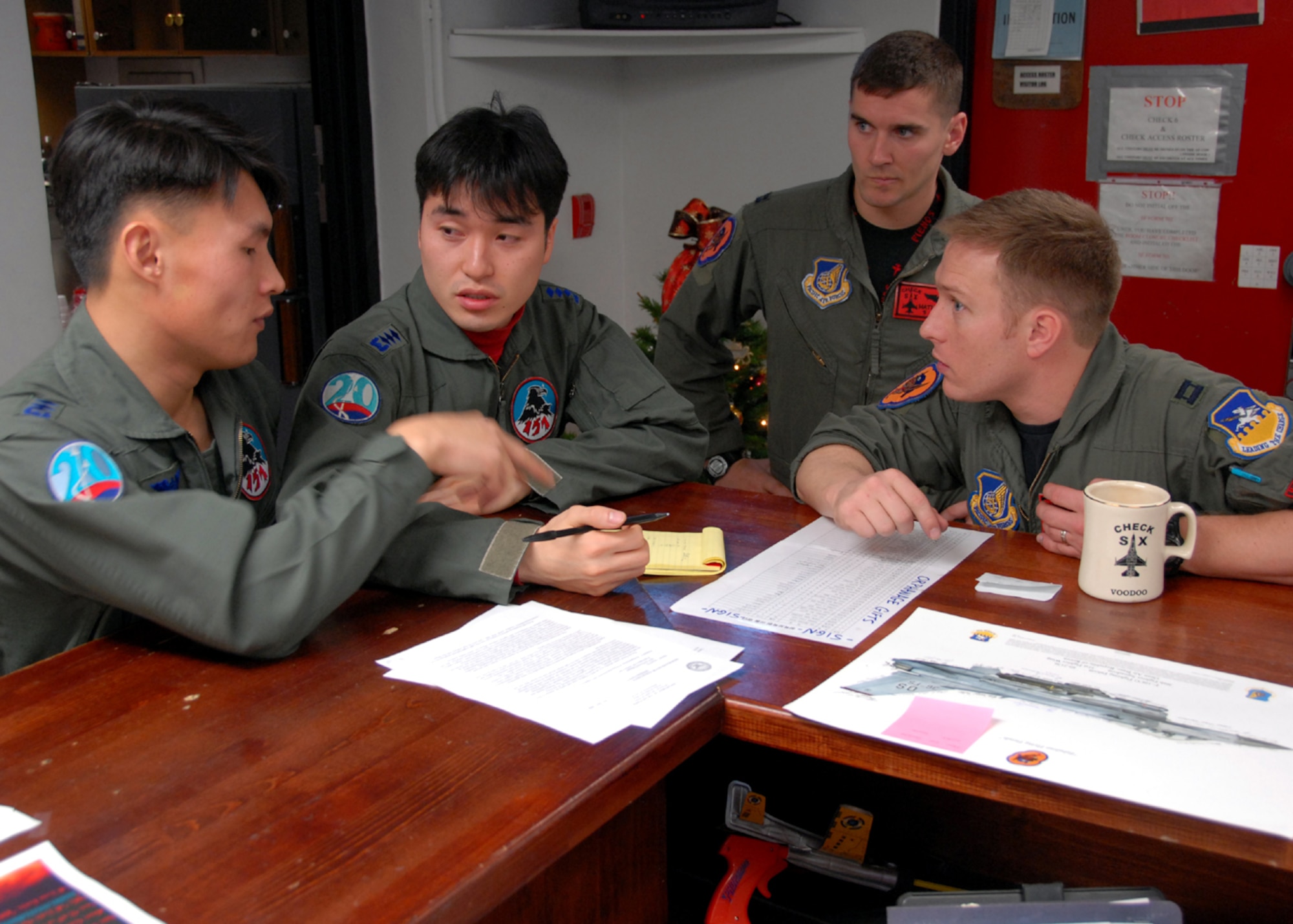 OSAN AIR BASE, Republic of Korea – Captain Jeong-Ho Cho (left), and Captain Young-Kwon Ko (second from left) both KF-16C Fighting Falcon pilots assigned to the 157th Tactical Fighter Squadron, Seosan Air Base, Republic of Korea Air Force, conduct flight planning with Captain William Bolton and Captain Paul Davidson (right) both F-16C Fighting Falcon pilots assigned to the 36th Fighter Squadron, during the Buddy Wing program 11 through 13 December.  The purpose of the Buddy Wing program is to exchange ideas, introduce tactics and improve interoperability between the U.S. and Republic of Korea Air Forces.  (U. S. Air Force photo by Senior Master Sgt Marvin Krause)