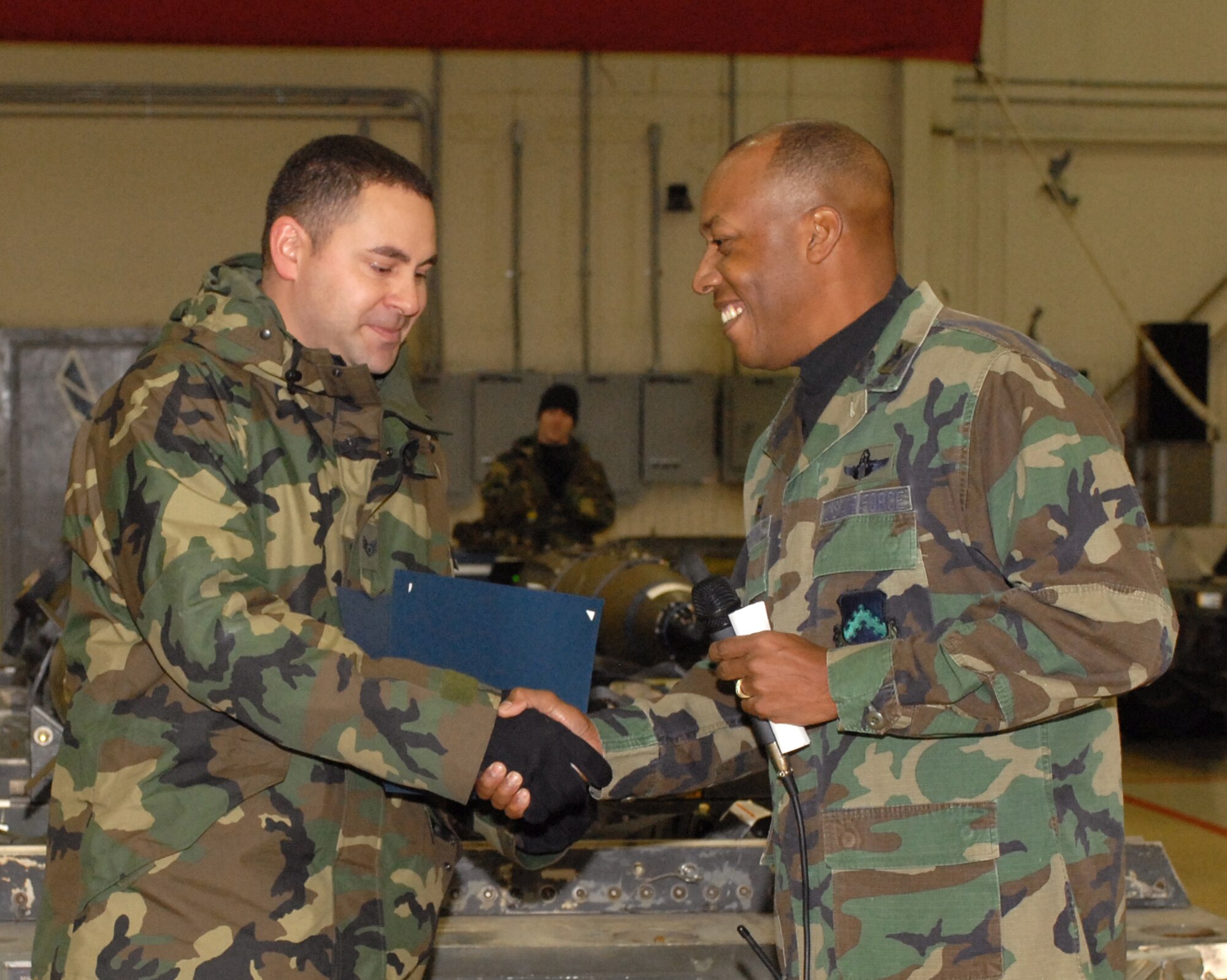 KUNSAN AIR BASE, South Korea--Staff Sergeant Jack Stanley, a weapon specialist from the 8th Maintenance Group, shakes hand with Col. CQ "Wolf" Brown, 8th Fighter Wing commander, Dec. 14 here.  During the weapon load competition, Staff Sgt. Jack Stanley is step promoted to the rank of Technical Sergeant by Col. CQ "Wolf" Brown. (U.S. Air Force photo/Senior Airman Giang Nguyen)
