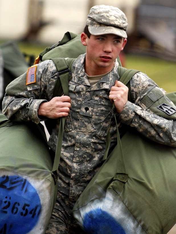 Spc.Deryk Hutton, of the 76th Infantry Brigade Combat Team with the Indiana Army National Guard, carries his duffle bags after unloading them at Camp Atterbury Joint Maneuver Training Center in Edinburgh, Ind., Dec. 13, 2007. 