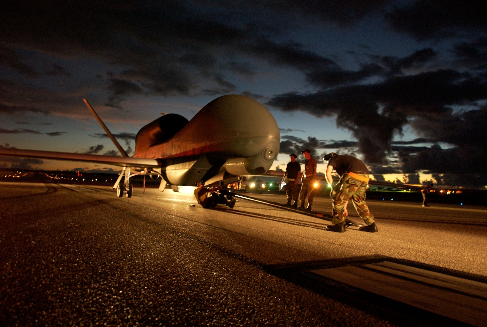A flightline ground crew secures the Global Hawk for towing to a secure hanger on Andersen July 19.  The aircraft has a wing span of 116 feet and is designed to cruise at extremely high altitudes. (U.S. Air Force photo/Senior Airman Miranda Moorer)                            