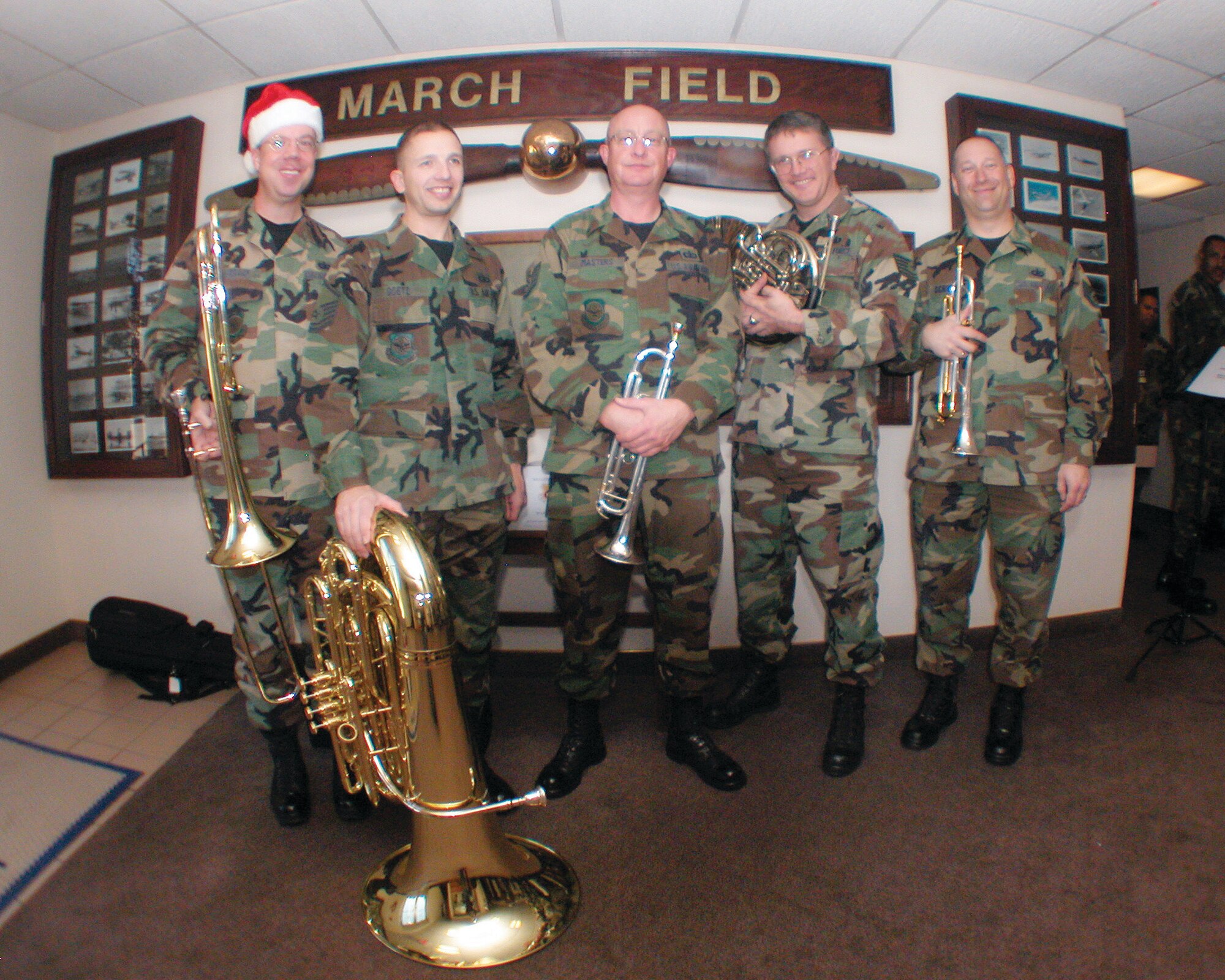 The U.S. Air Force Band of the Golden West from Travis Air Force Base, Calif., poses for a quick shot in the wing headquarters during their visit to March ARB. On Tuesday, they performed at various locations around base. Their last set of the afternoon was played at the Moreno Valley City Hall. The Holiday caroling group is comprised of Master Sgt. Michael Goetz, Technical Sgts. James Masters and Tom Hanrahan and Staff Sgts Scott Ruedger and Ed Schubert. (U.S. Air Force photo by Amy Abbott)