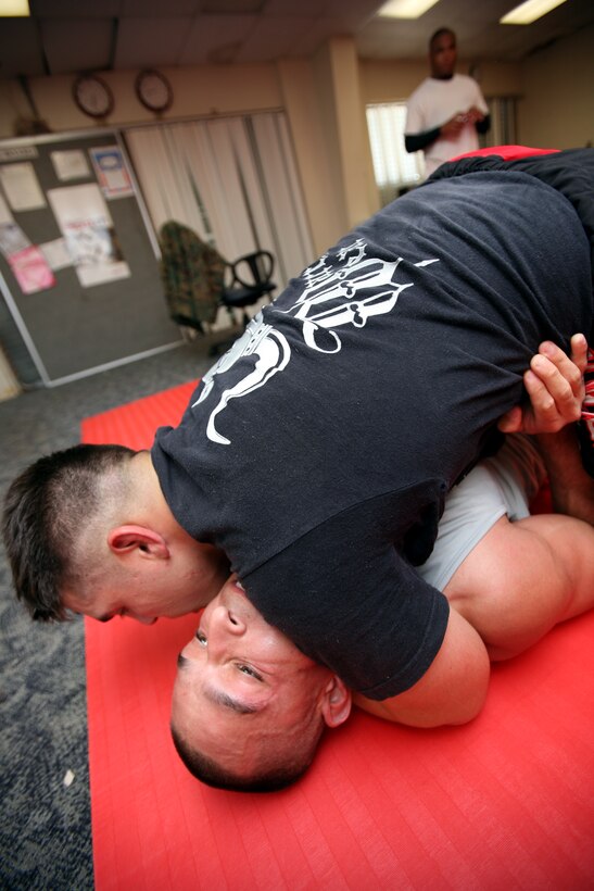 MARINE CORPS BASE, CAMP H.M. SMITH, Hawaii -- Cpl. Tom Becerra puts the squeeze on Sgt. Julio Sandoval as Sandoval braces himself in the guard position. In mixed martial arts any position can be turned to your advantage. Soon after, Sandoval had the upper hand and put the squeeze on Becerra.