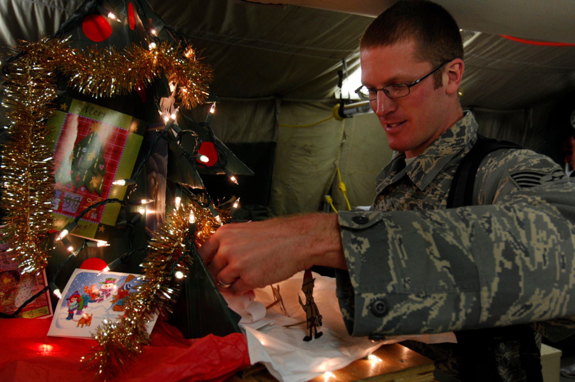 BAGRAM AIR BASE, Afghanistan - Tech. Sgt. Ryan McMaster, an aircrew life support technician with the 774th Expeditionary Airlift Squadron here, places figures for a holiday diorama next to a tree that he created with locally-procured materials, Dec. 14, 2007.   (U.S. Air Force photo/Staff Sgt. Joshua T. Jasper)