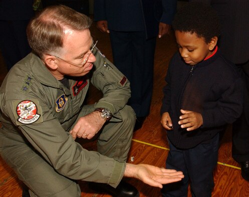 ANDREWS AIR FORCE BASE, Md. -- Lt. Gen. John A. Bradley, commander of Air Force Reserve Command, gives a coin to the son of 459th Aeromedical Staging Squadron retiree Tech. Sgt. Gail Holley, in exchange for a playful "gimme five" at the 459th Air Refueling Wing commander's call Dec. 8. General Bradley attended the call to recognize star performers, chat with Airmen and discuss topics relevant to the AFRC. (U.S. Air Force photo/Staff Sgt. Amaani Lyle)