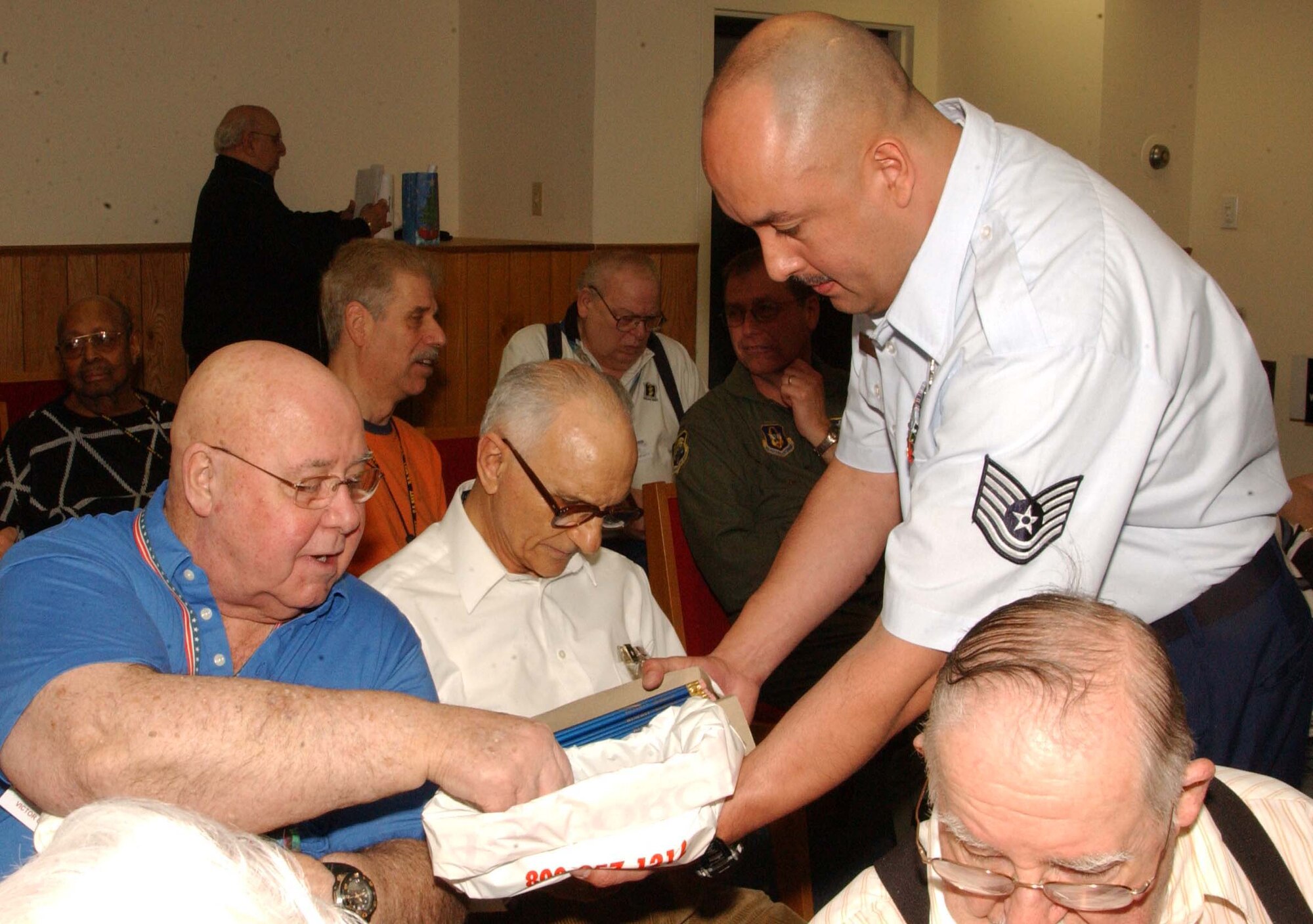 WASHINGTON, D.C. -- (Right) Tech. Sgt. Oscar Paez, 459th Maintenance Operations Flight, hands out raffle tickets to residents of the Armed Forces Retirement Home Dec. 14. Wing members visited the home to thank veterans for their service and distribute gifts for the holiday season. (U.S. Air Force photo/Staff Sgt. Amaani Lyle)