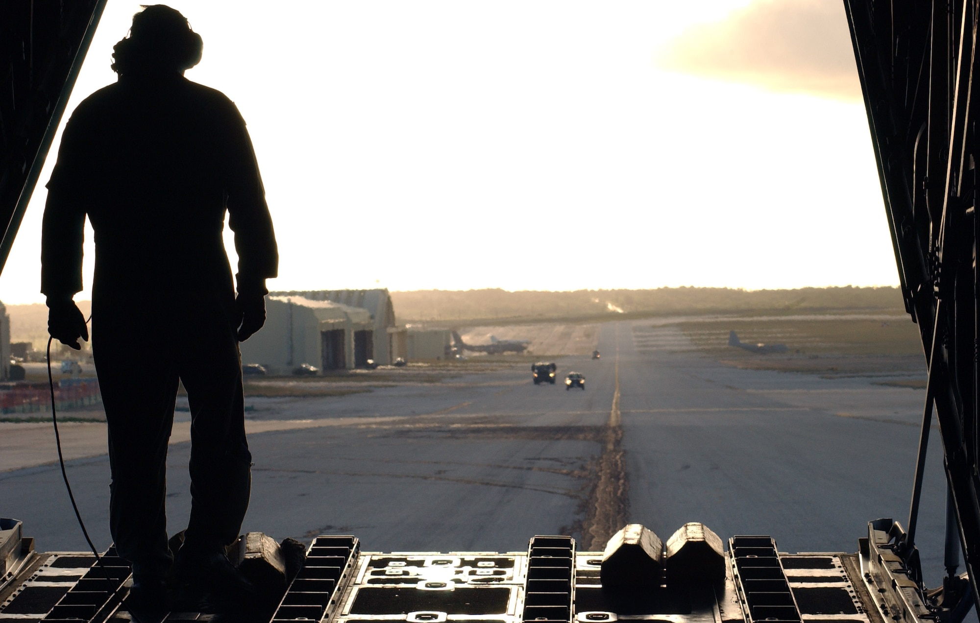 Chief Master Sgt. Michael Sundberg stands in the back of his C-130 Hercules and observes the Andersen Air Force Base, Guam, airfield after finishing the day's aerial deliveries. Three C-130s flew over the surrounding islands in the Western Pacific region Dec. 14 participating in Operation Christmas Drop, and will continue through Dec.18. Chief Sundberg is with the 36th Airlift Squadron at Yokota Air Base, Japan. (U.S. Air Force photo/Senior Airman Brian Kimball) 