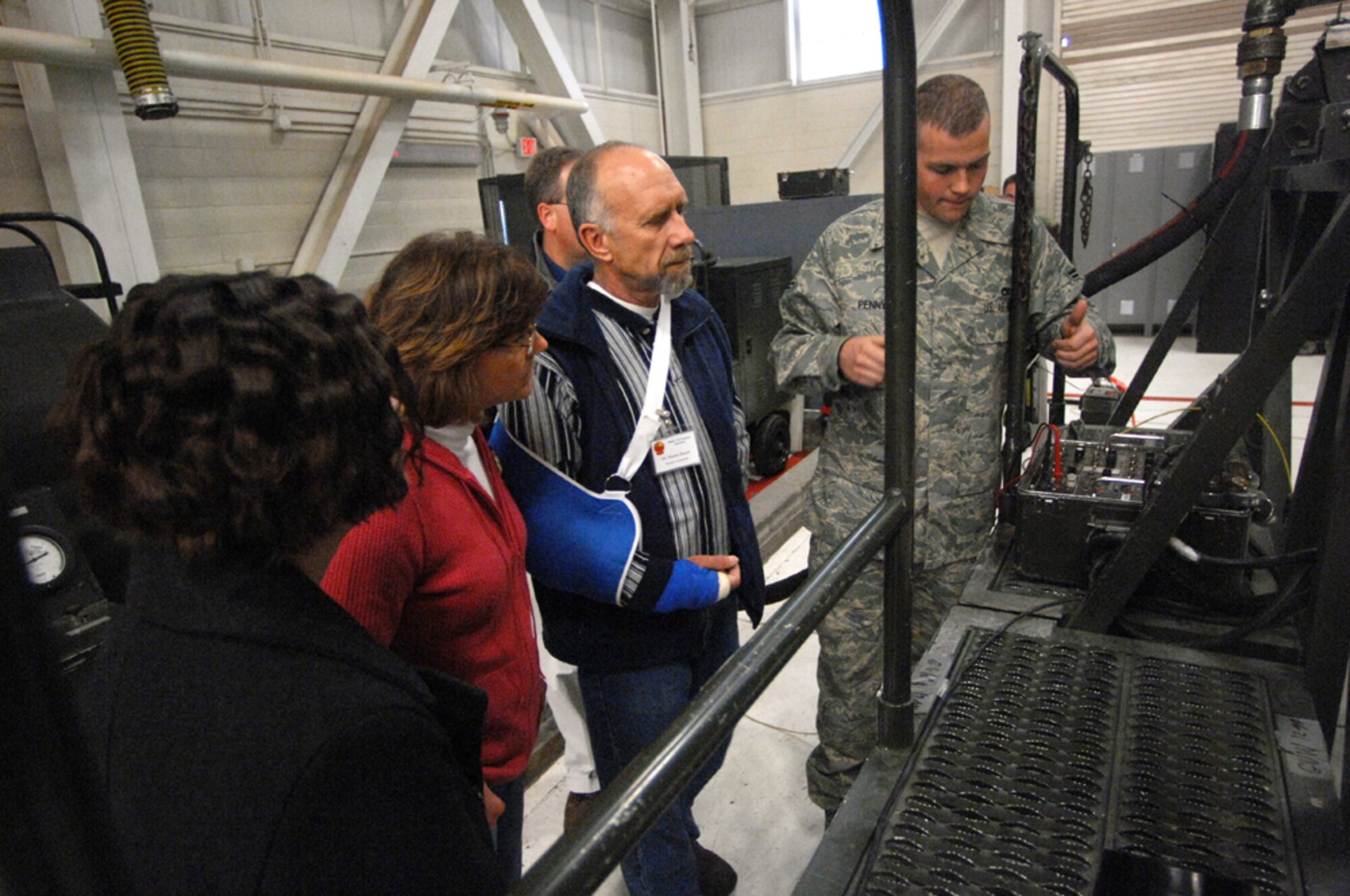 MOUNTAIN HOME AIR FORCE BASE, Idaho -- Airman 1st Class Thomas Penny, 366th Component Maintenance Squadron, shows honorary commanders how a conformal fuel tank is tested for leaks during their tour here, Dec 7. The visit provided more than 20 of the wing’s honorary commanders an interactive, hands-on experience of maintenance operations and the opportunity to meet the Airmen who make it happen. (U.S. Air Force photo/ Airman 1st Class Ryan Crane)