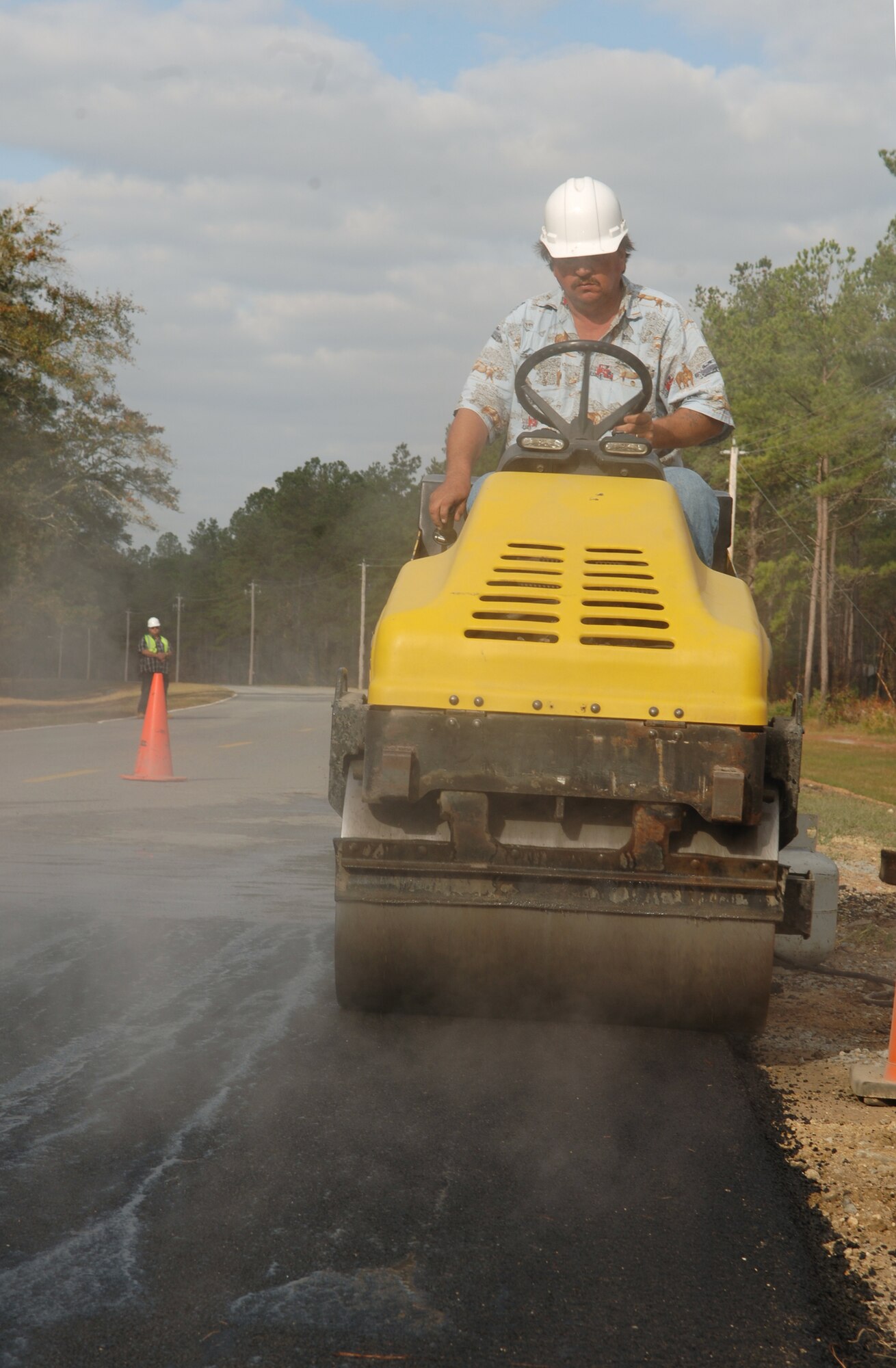 Richard Bates, B&B Paving heavy equipment operator, rolls newly applied asphalt on Moody’s Burma Road recently. Several road and parking lot construction projects are currently underway around the base to enhance security and infrastructure. (U.S. Air Force Photo by Senior Airman Schelli Jones)