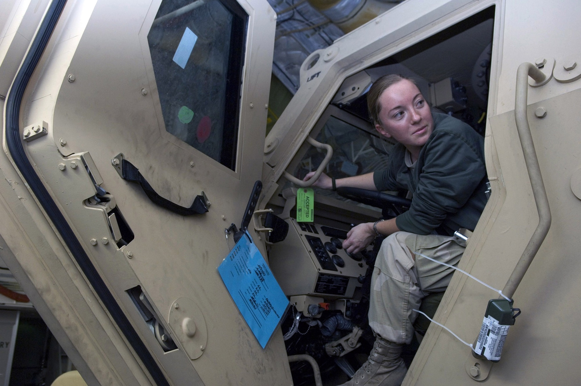 Senior Airman Christine Mirgon takes a quick look behind her as she loads a new mine resistant ambush protected vehicle on to a C-17 Globemaster III on the flightline Dec. 8 at Balad Air Base, Iraq. Airman Putrino and other aerial port team members broke the single-day cargo-movement record Dec. 6 here by moving more than 400 tons of cargo. Airman Mirgon is a 332nd Expeditionary Logistics Readiness Squadron member deployed from Offut Air Force Base, Neb. (U.S. Air Force photo/Staff Sgt. Travis Edwards)