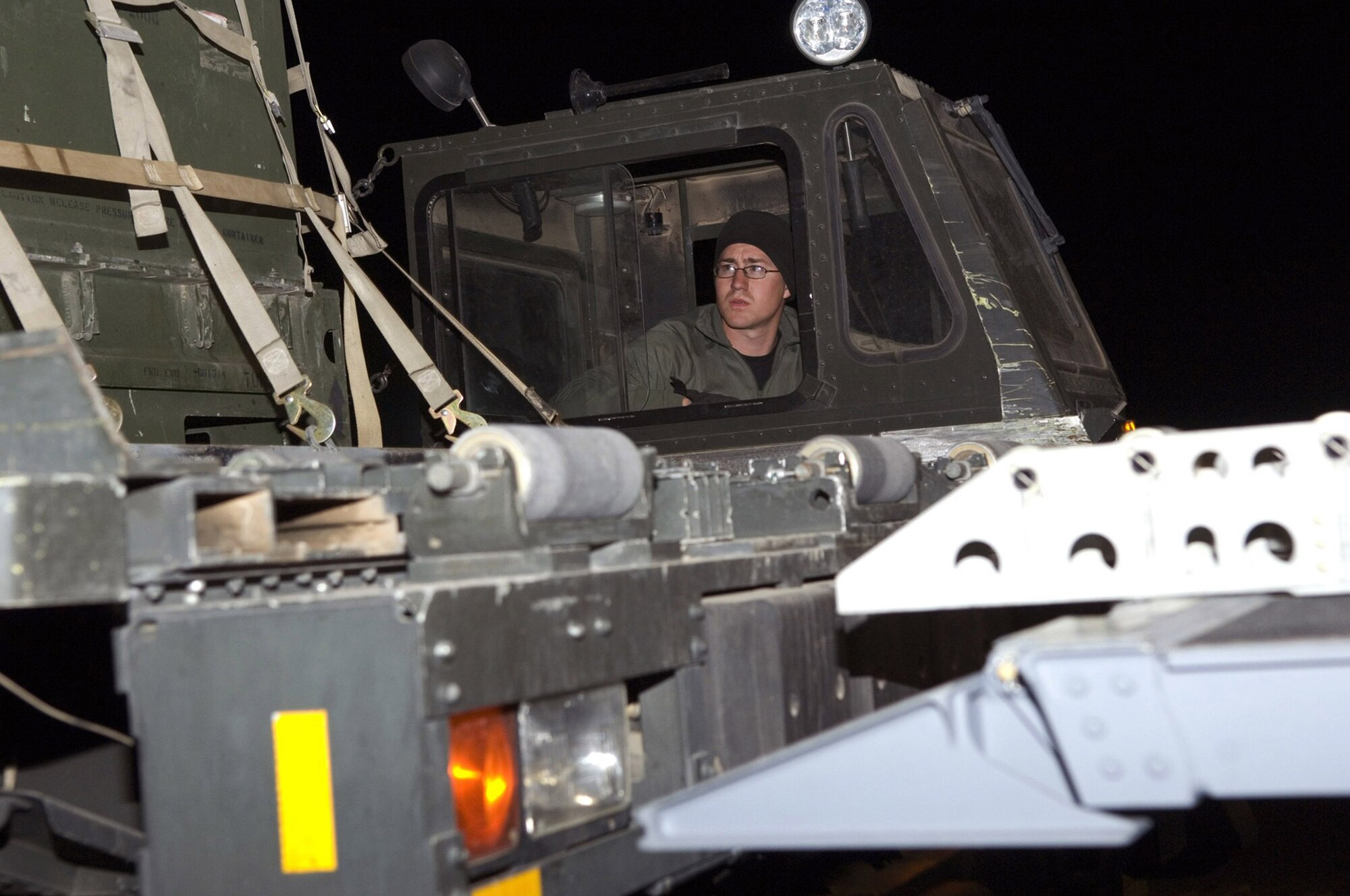 Senior Airman Jeff Johnson watches as the pallets come off the cargo loader onto an aircraft Dec. 8 at Balad Air Base, Iraq. The aircraft cargo loaders can move the cargo forward automatically, completing some of the grueling work often done by the aerial porters. Airman Johnson is a 332nd Expeditionary Logistics Readiness Squadron transportation specialist deployed from Altus Air Force Base, Okla. (U.S. Air Force photo/Staff Sgt. Travis Edwards)