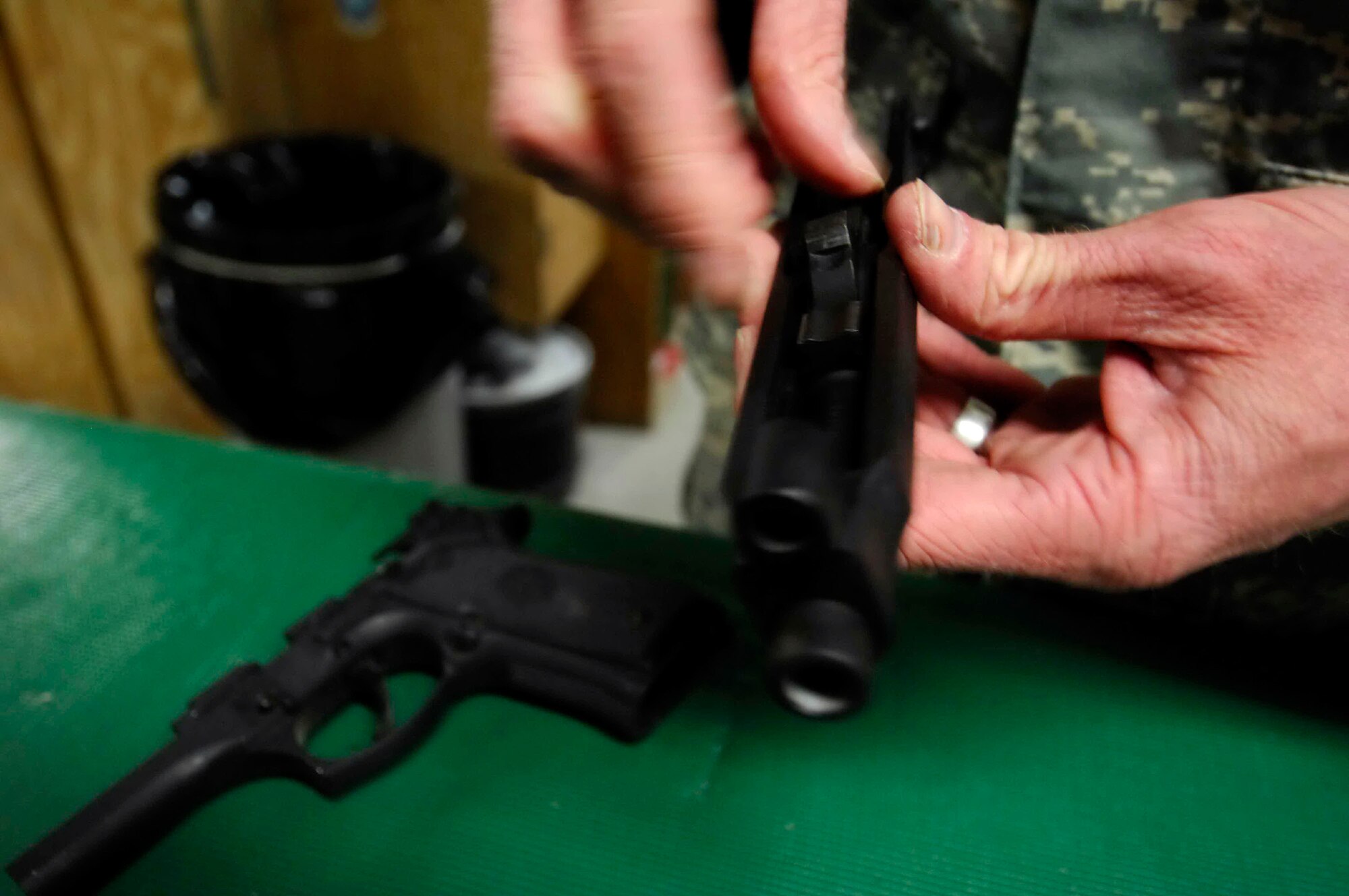 Tech. Sgt. Ryan McMaster cleans an M-9 pistol before putting it back into a secure gun rack Dec. 12 at Bagram Air Base, Afghanistan. Sergeant McMaster, a 774th Expeditionary Airlift Squadron aircrew life support technician, manages and performs inspections, maintenance and adjustments of aircrew life support equipment. (U.S. Air Force photo/Staff Sgt. Joshua T. Jasper) 