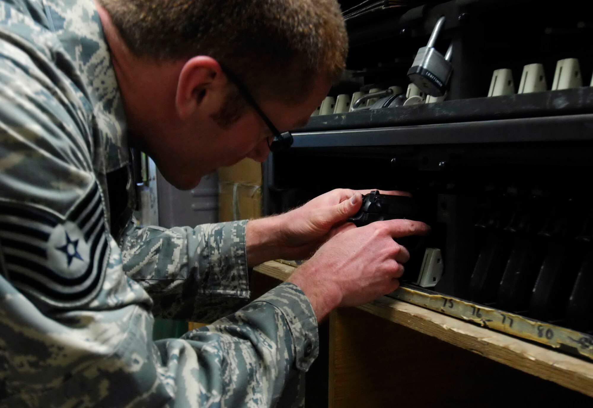 Tech. Sgt. Ryan McMaster cleans an M-9 pistol before putting it back into a secure gun rack Dec. 12 at Bagram Air Base, Afghanistan. Sergeant McMaster, a 774th Expeditionary Airlift Squadron aircrew life support technician, manages and performs inspections, maintenance and adjustments of aircrew life support equipment. (U.S. Air Force photo/Staff Sgt. Joshua T. Jasper)
