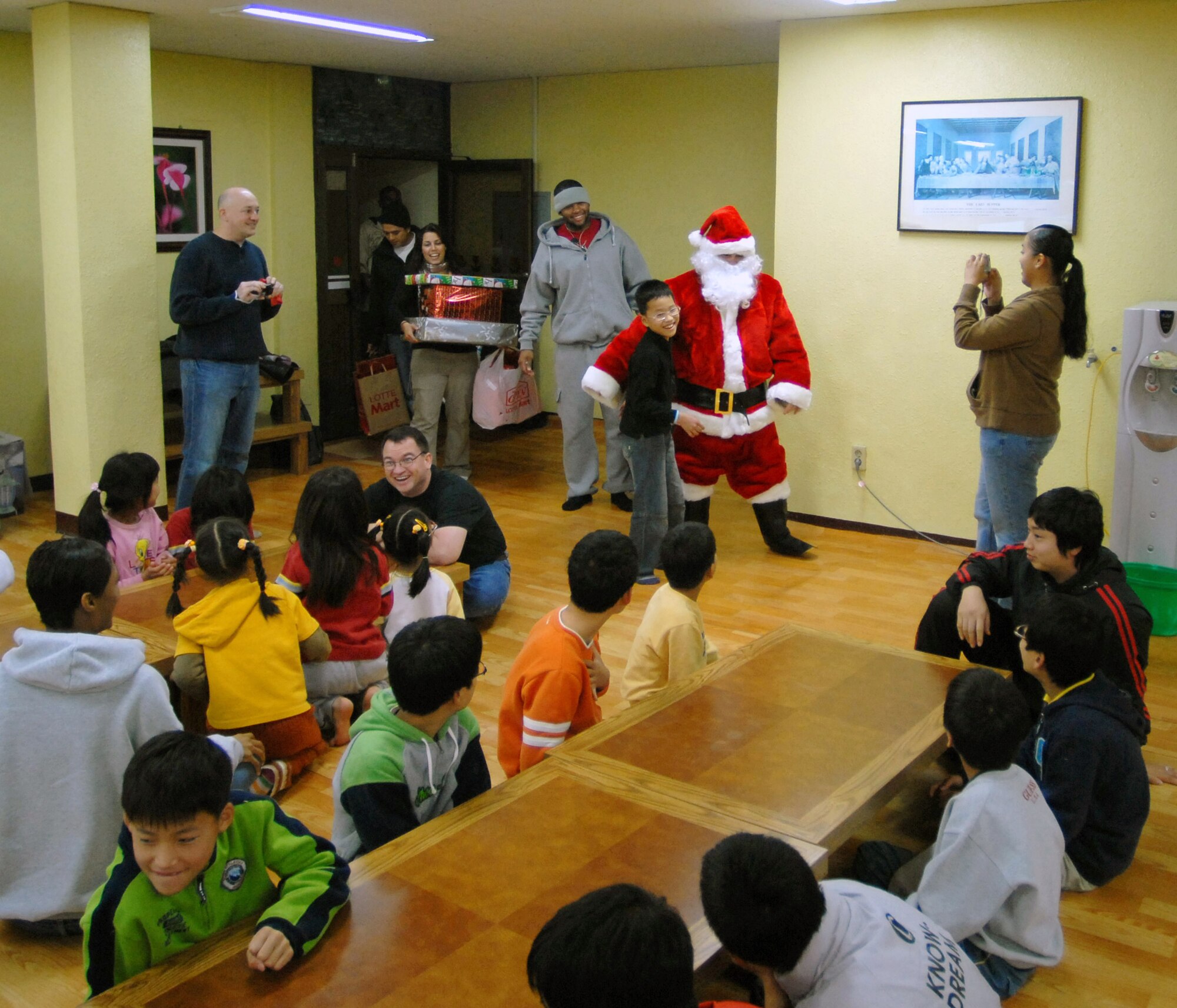 Santa, played by Tech. Sgt. John Craven, makes a surprise visit to the Kae Jong orphanage to hand out gifts Dec. 15 in Kae Jong, South Korea. Airmen from Kunsan Air Base, South Korea, spent the afternoon handing out gifts, coloring, eating, and playing with children during an Airmen Committed to Excellence-sponsored trip. The Airmen donated various gifts to include beanie babies and a PlayStation 2. (U.S. Air Force photo/Senior Airman Steven R. Doty) 
