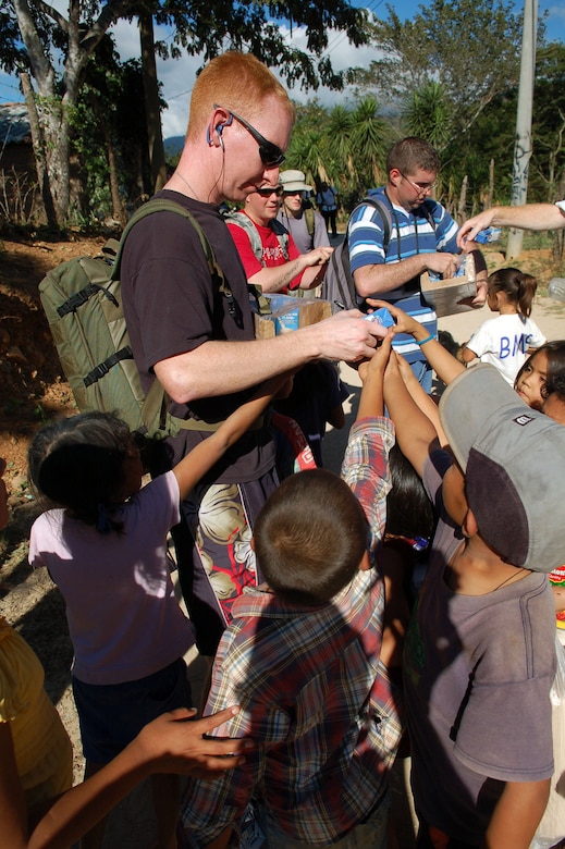 CAPIRO, Honduras -- Air Force Staff Sgt. Charles Alford hands milk to a crowd of children in the village of Capiro Dec. 14.  The sergeant was one of about 60 servicemembers who attended a three-mile hike, sponsored by the JTF-Bravo chapel, to the village to deliver 600 pounds of food.  (U.S. Air Force photo by Staff Sgt. Austin M. May)