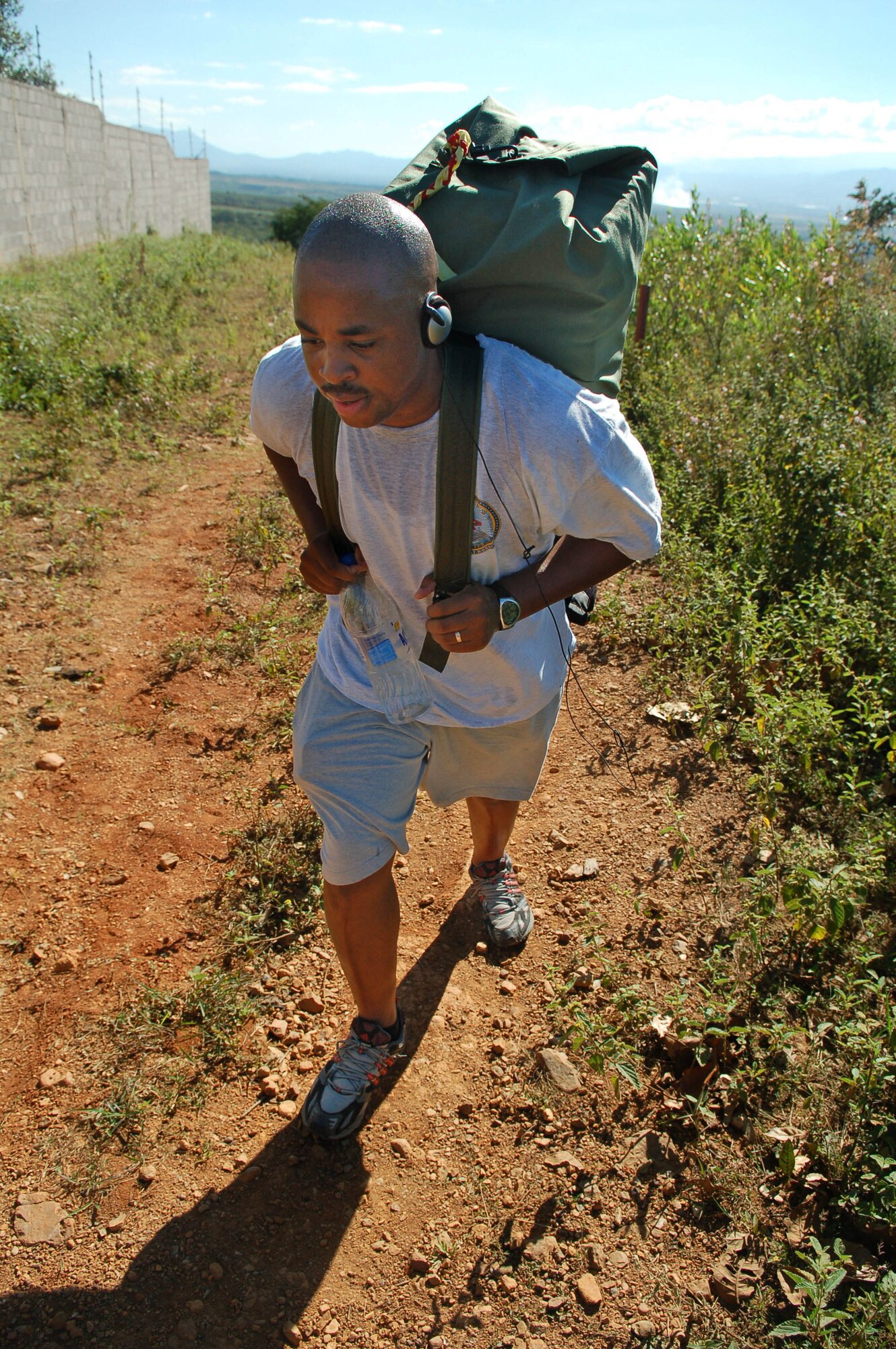 CAPIRO, Honduras -- Navy Petty Officer 2nd Class Frank Johnson hikes up a hill as part of a group of about 60 servicemembers assigned to Joint Task Force-Bravo which delivered approximately 600 pounds of food to the village of Capiro Dec. 14.  The three-mile hike, sponsored by the JTF-Bravo chapel, was the fourth in a series of five scheduled trips.  (U.S. Air Force photo by Staff Sgt. Austin M. May)
