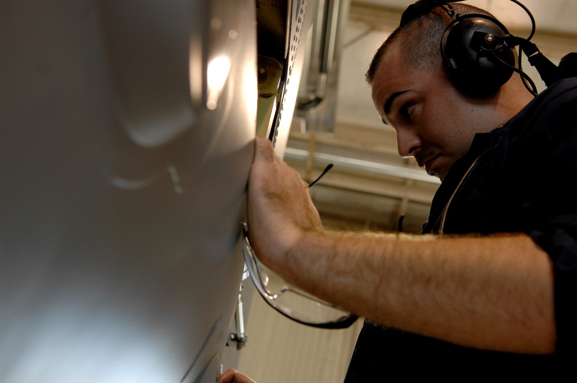 MOODY AIR FORCE BASE, Ga. -- Staff Sgt. Thomas Breining, 23rd Equipment Maintenance Squadron crew chief, Checks an area under a panel on an A-10C Thunderbolt II during a phase inspection here Dec 13.  Phase inspections are in-depth tear-downs of hard-to-reach areas after every 400 flying hours to ensure the aircraft are fully prepared for combat missions. (U.S. Air Force photo by Airman 1st Class Gina Chiaverotti)
