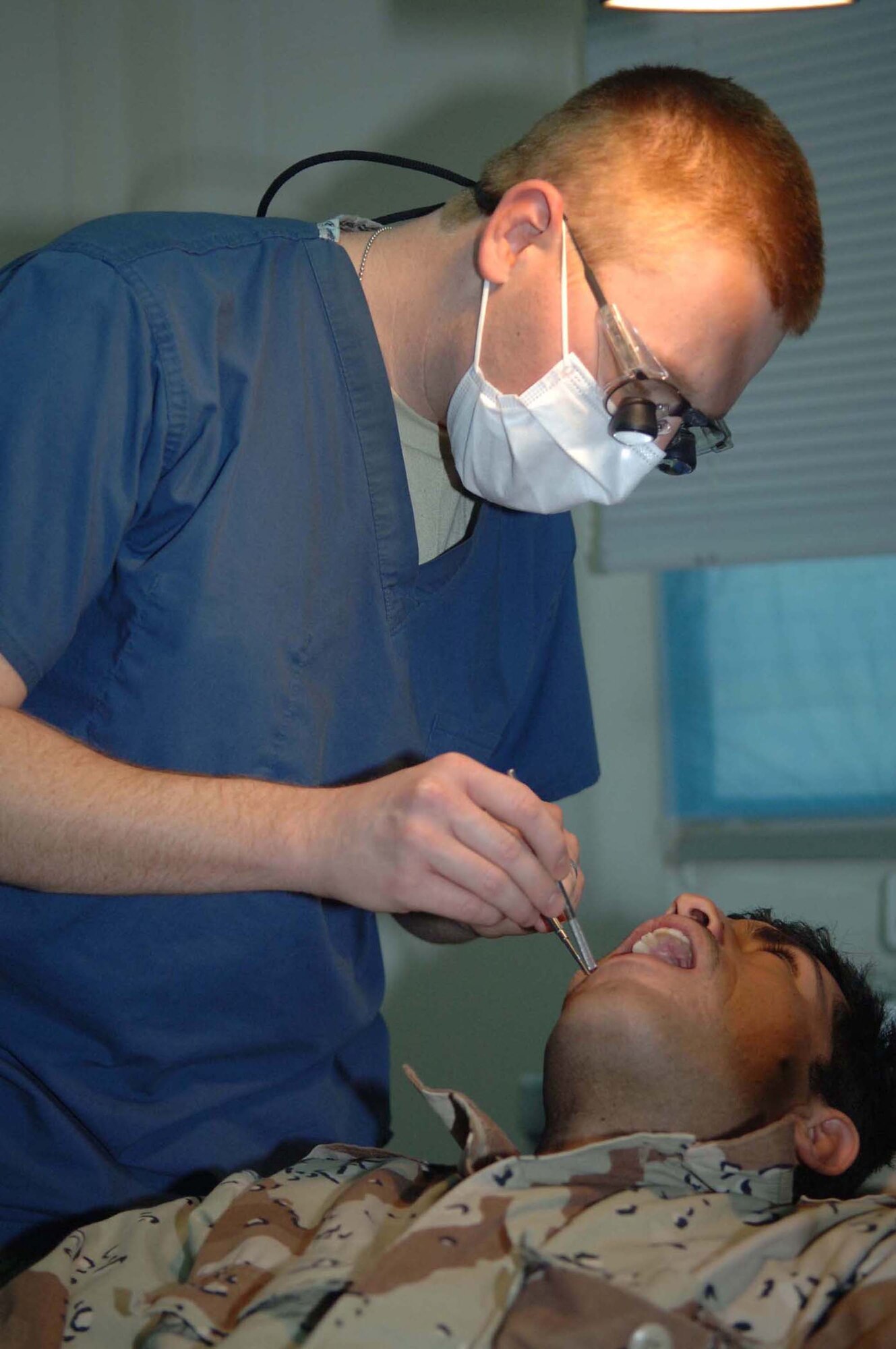 Capt. Lanny Giesler extracts a tooth from an Iraqi special forces soldier Dec. 5 at Victory Base Complex, Iraq. Captain Giesler, a Special Operations Iraqi Transition Team dental adviser, is deployed from Little Rock Air Force Base, Ark. (U.S. Air Force photo/Senior Airman Terri Barriere) 

