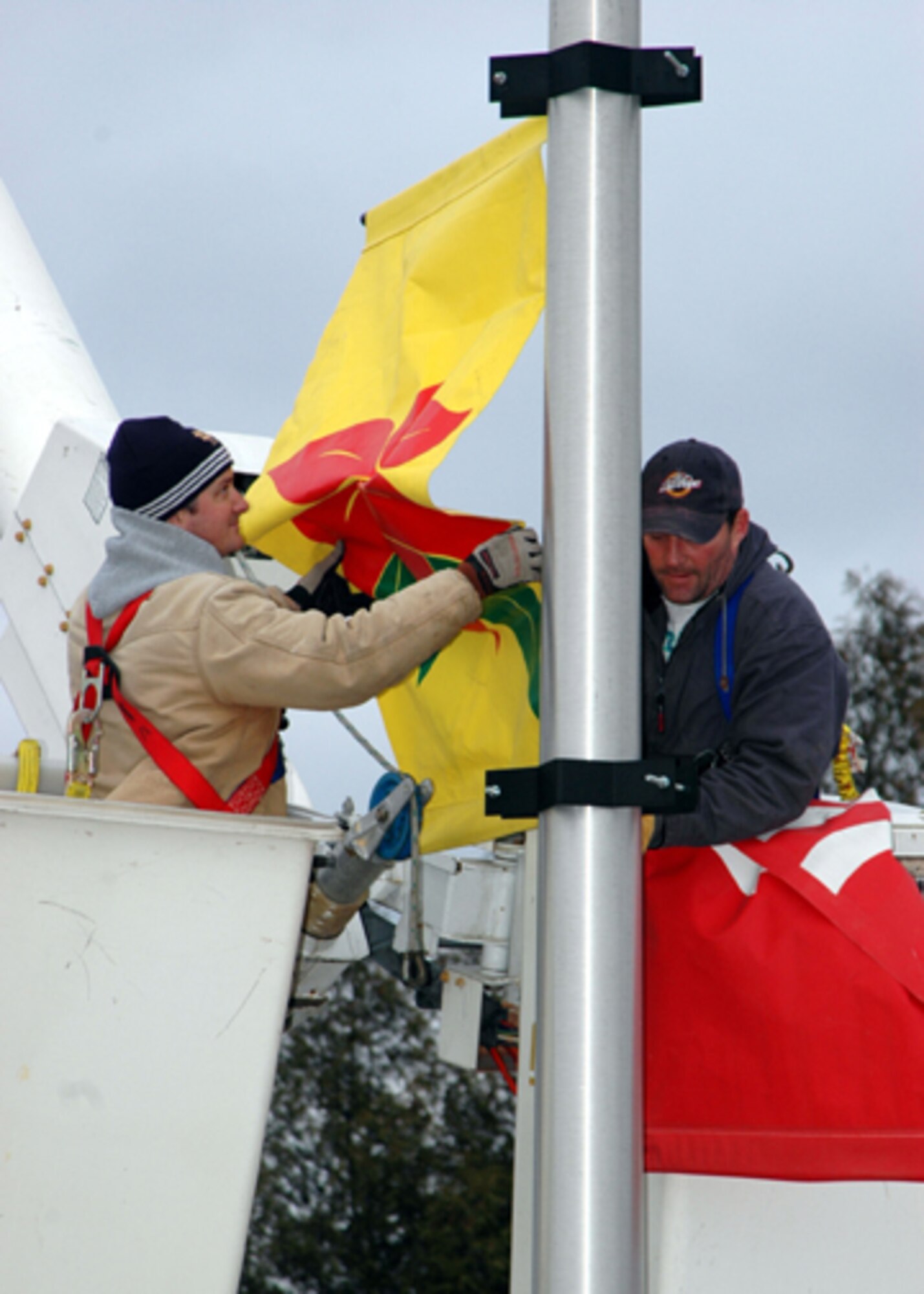 GRISSOM AIR RESERVE BASE, Ind., -- It is beginning to look a lot like Christmas at Grissom. Lane Flitcraft, heavy equipment operator and Dana Watson, a grounds maintainer with Data Monitor Systems, decorated the lamp posts on base with seasonal banners.   (U.S. Air Force photo/Senior Airman Carl Berry)