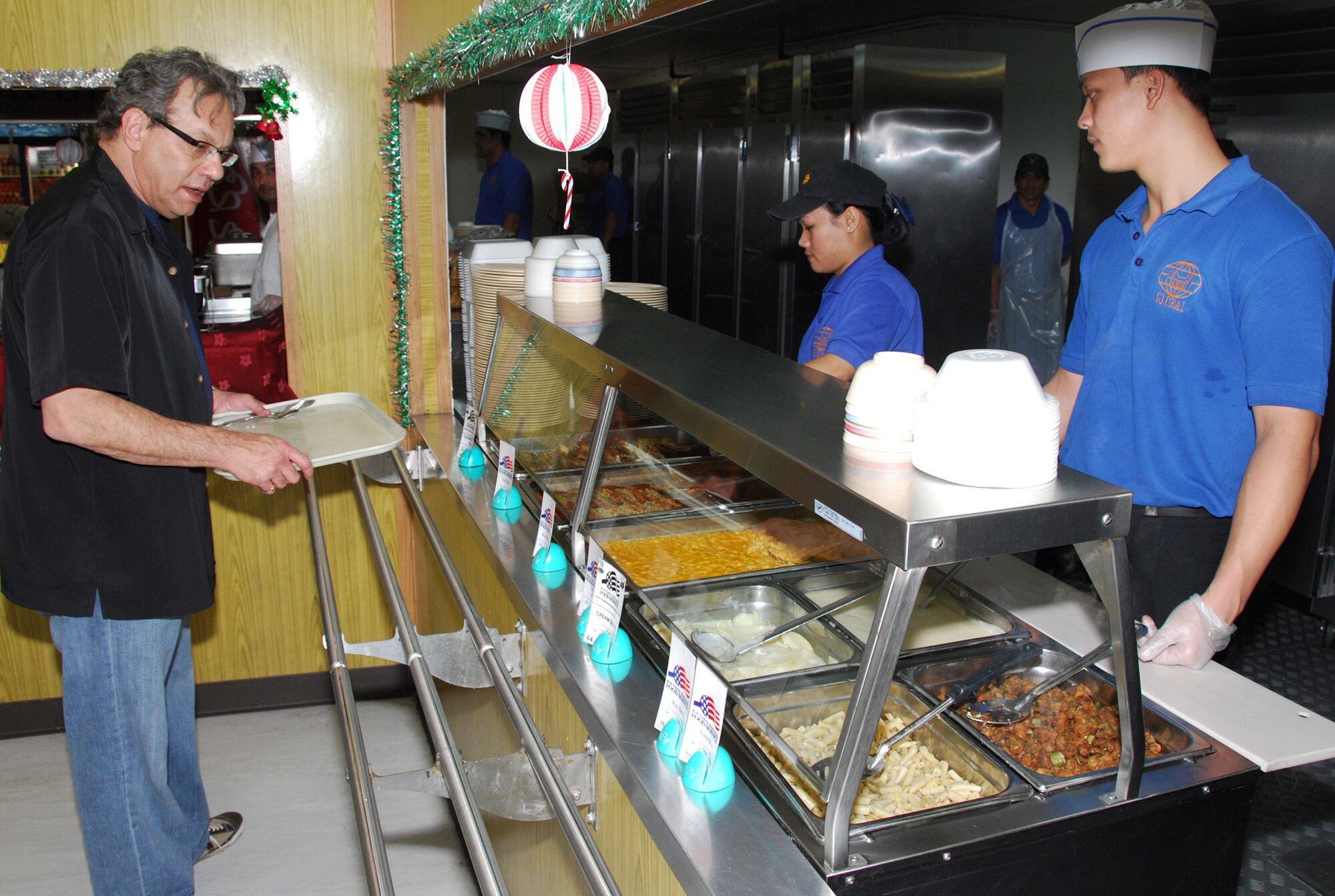 SOUTHWEST ASIA - Lewis Black mulls a dining choice at the Independence Dining Facility after at a Southwest Asia air base Dec. 17. Mr. Black is one of the celebrities touring with the USO 2007 holiday show. (U. S. Air Force photo/Staff Sgt. Douglas Olsen)
