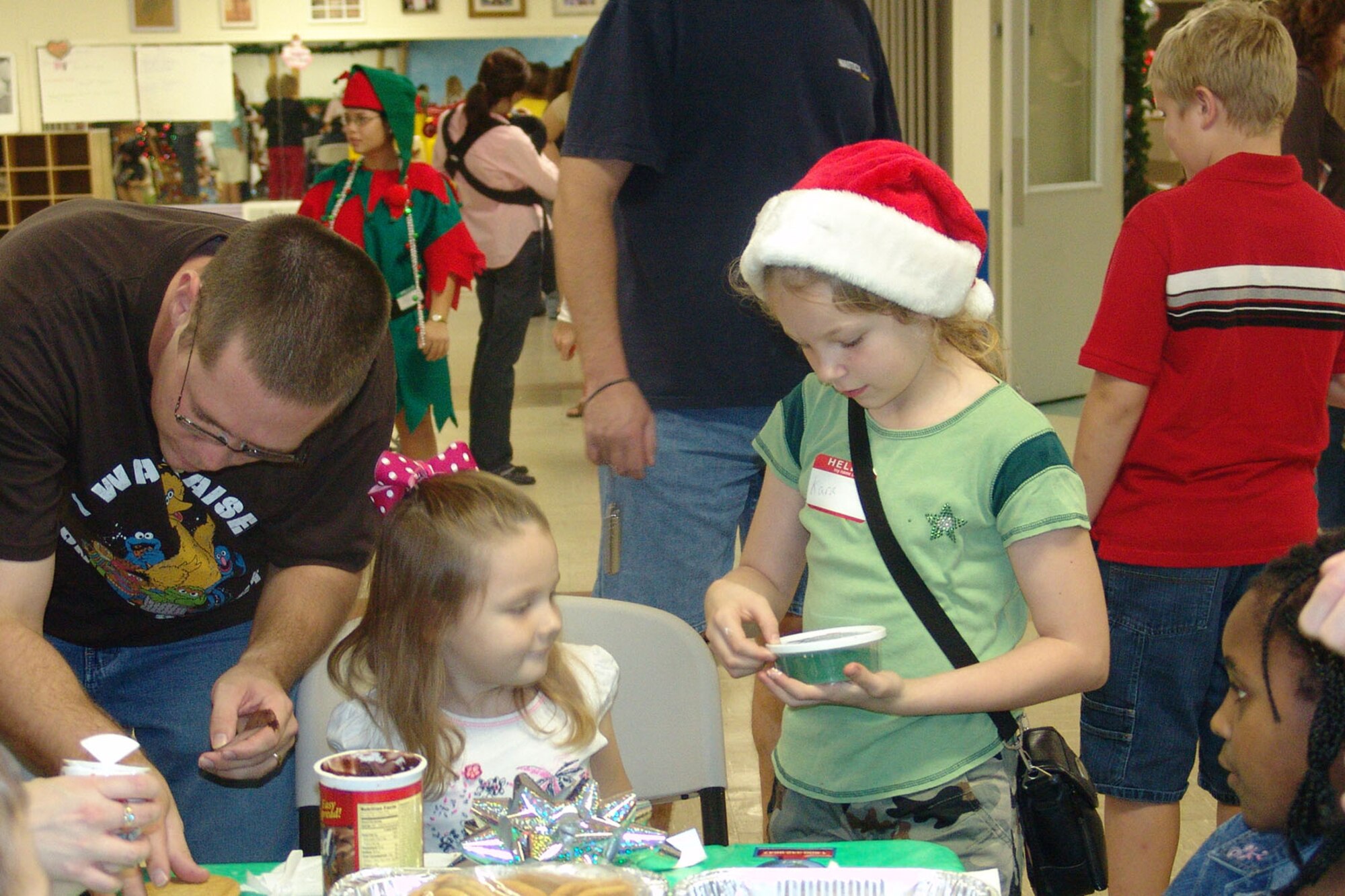 EGLIN AIR FORCE BASE, Fla. -- Kara Boudreaux helps Ciana Ray decorate a cookie during the Hearts Apart Holiday Christmas party.  The Airman and Family Readiness Center sponsored the party for more than 100 spouses and their children Dec. 15. (USAF photo by Lois Walsh)