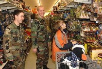 MINOT AIR FORCE BASE, N.D. -- (From left) Airman 1st Class Jesse Bufkin 791st Missile Forces Squadron, and Airman 1st Class Jonathan Marshik, 91st MSFS, look on as  Brandon Besselman picks out Christmas presents during Shop with A Cop day in Minot, Dec 16. Each of the 29 children were given a $150 gift card to spend on whatever they wanted. Shop with a cop was sponsored by Companions for Children and the kids were from the local community. The cops were from Minot Air Force Base, Highway Patrol, and the Minot Police Department. (U.S. Air Force photo by Airman 1st Class Cassandra Jones)