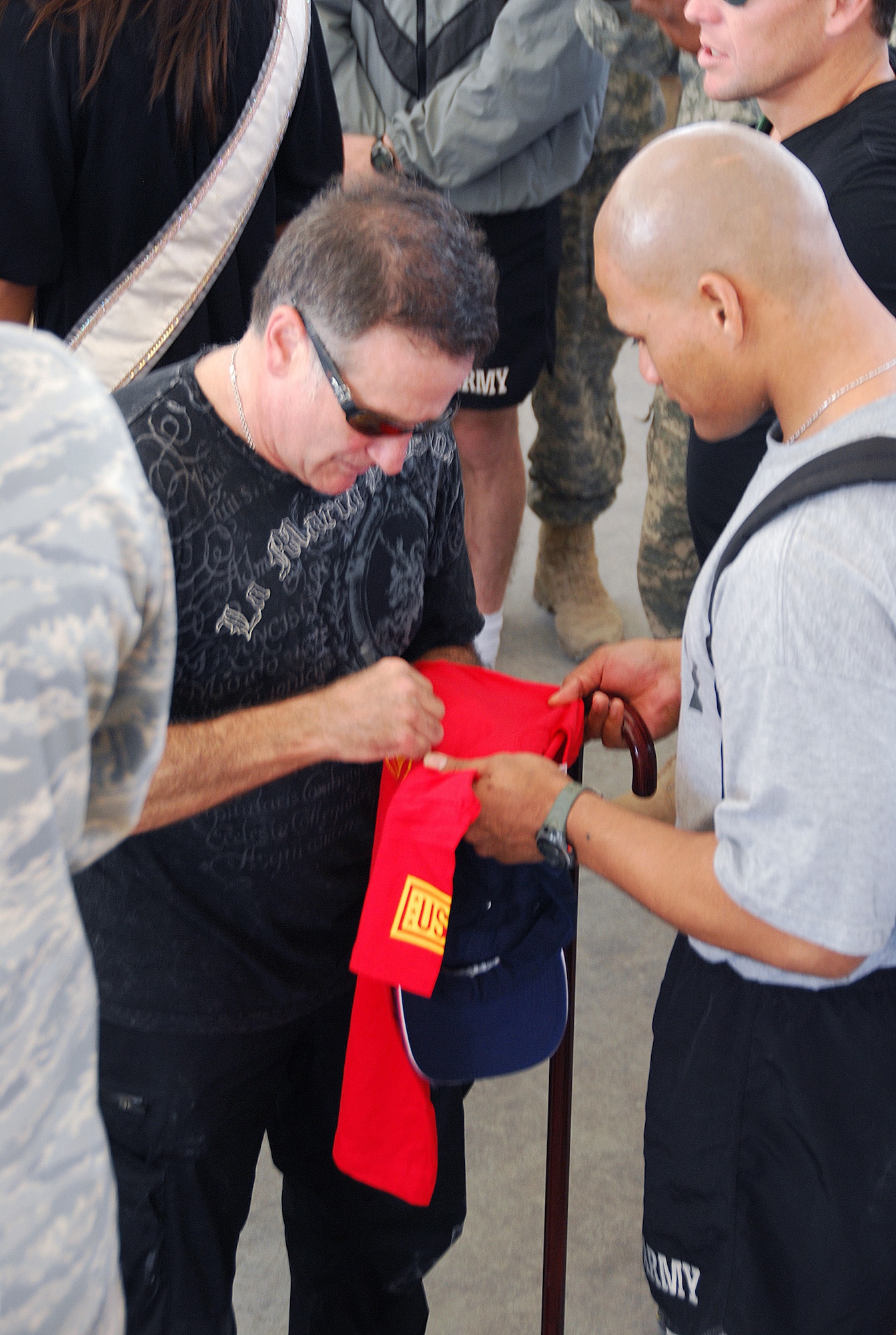 SOUTHWEST ASIA - Robin Williams signs a Tee shirt for U.S. Army Sergeant Semeli Toilolo during an appearance at a Southwest Asia air base Dec. 17. Sergeant Toilolo is recovering from wounds he received in a suicide bomber attack. Mr. Williams is touring with the USO as part of the 2007 holiday tour throughout Southwest Asia. Other celebrities on the tour included Rachel Smith, Miss USA, Kid Rock, Lewis Black and Lance Armstrong. (U. S. Air Force photo/Staff Sgt. Douglas Olsen)