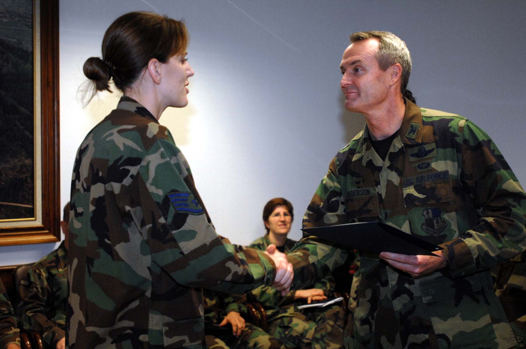SPANGDAHLEM AIR BASE, Germany – Staff Sgt. Erin Schmid, 52nd Equipment Maintenance Squadron, is recognized by Col. Darryl Roberson, 52nd Fighter Wing commander, for superior performance during an Environmental, Safety, Occupational Health, Compliance Assessment and Management Program Assessment Dec. 12, 2007. (U.S Air Force photo/ Airman First Class Jenifer Calhoun)
