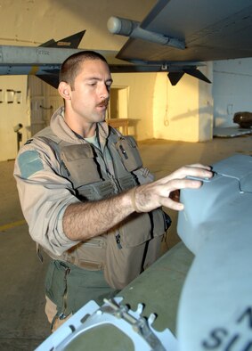 BALAD AIR BASE, Iraq -- Capt. Zach Manning, a 4th Expeditionary Fighter Squadron alert pilot, inspects his F-16 Fighting Falcon here. Alert pilots inspect their aircraft after missions instead of before to save pilots time when they’re called to duty. Captain Manning is deployed from Hill Air Force Base, Utah. (U.S. Air Force photo/Senior Airman Terri Barriere)